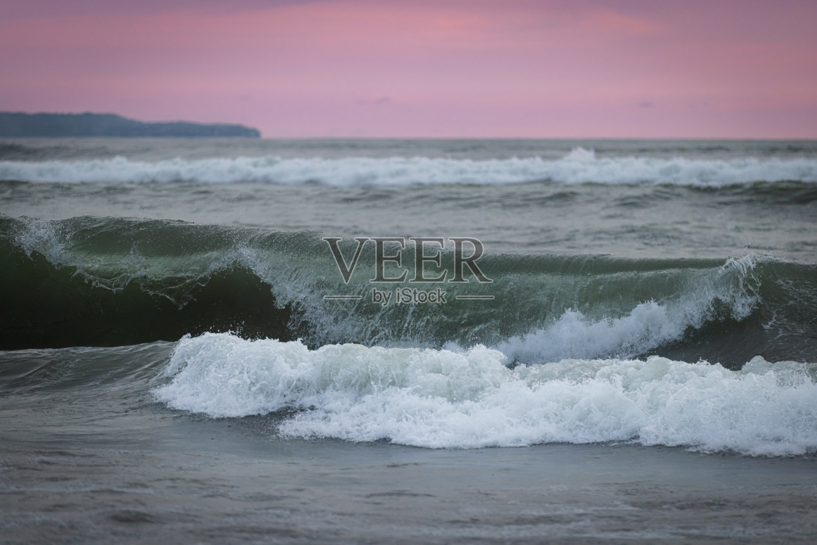 日落时分的昌古海滩风景，海浪拍打着岸边。照片摄影图片