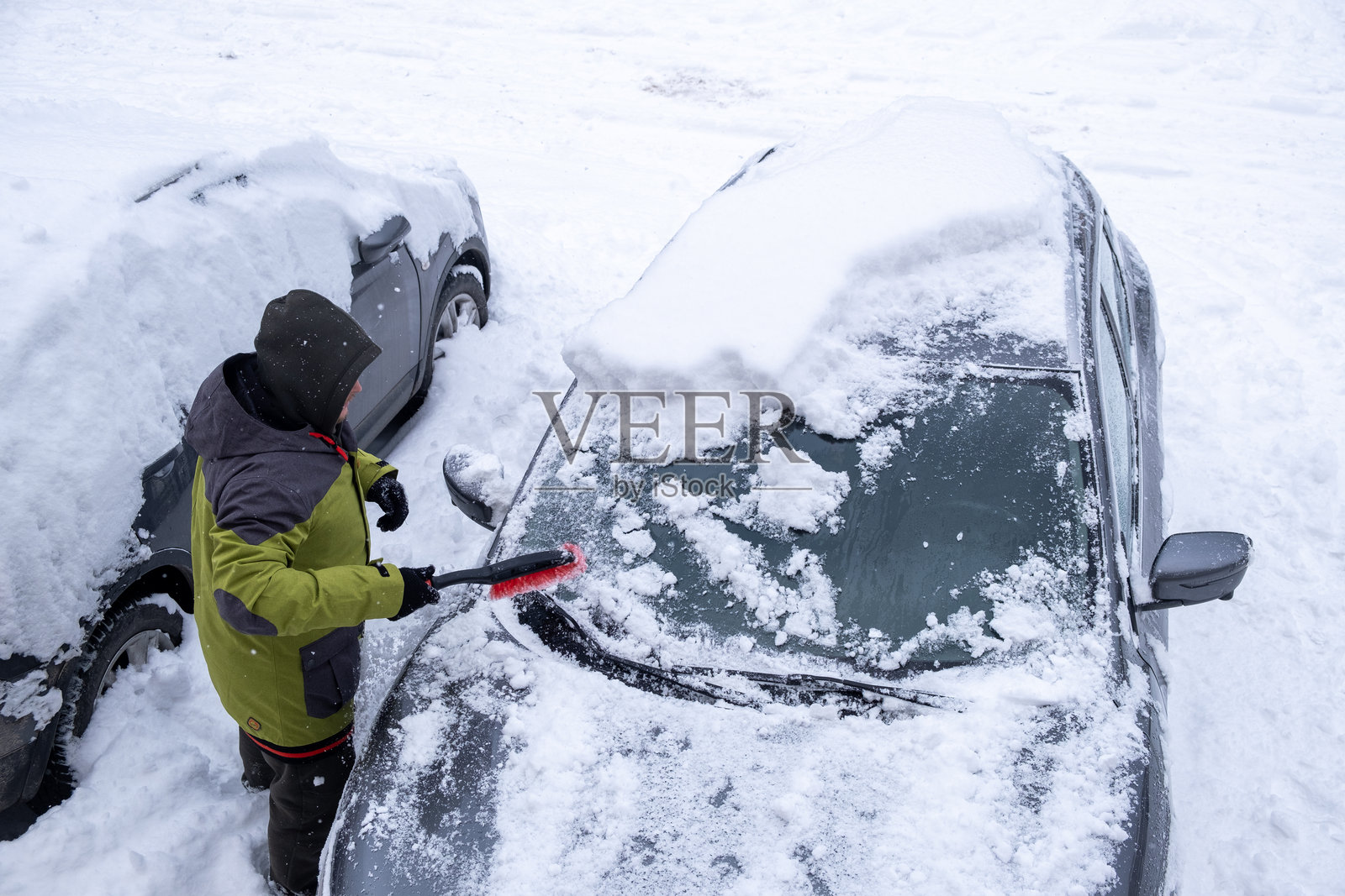 冬季风景中清理汽车上的雪的人照片摄影图片