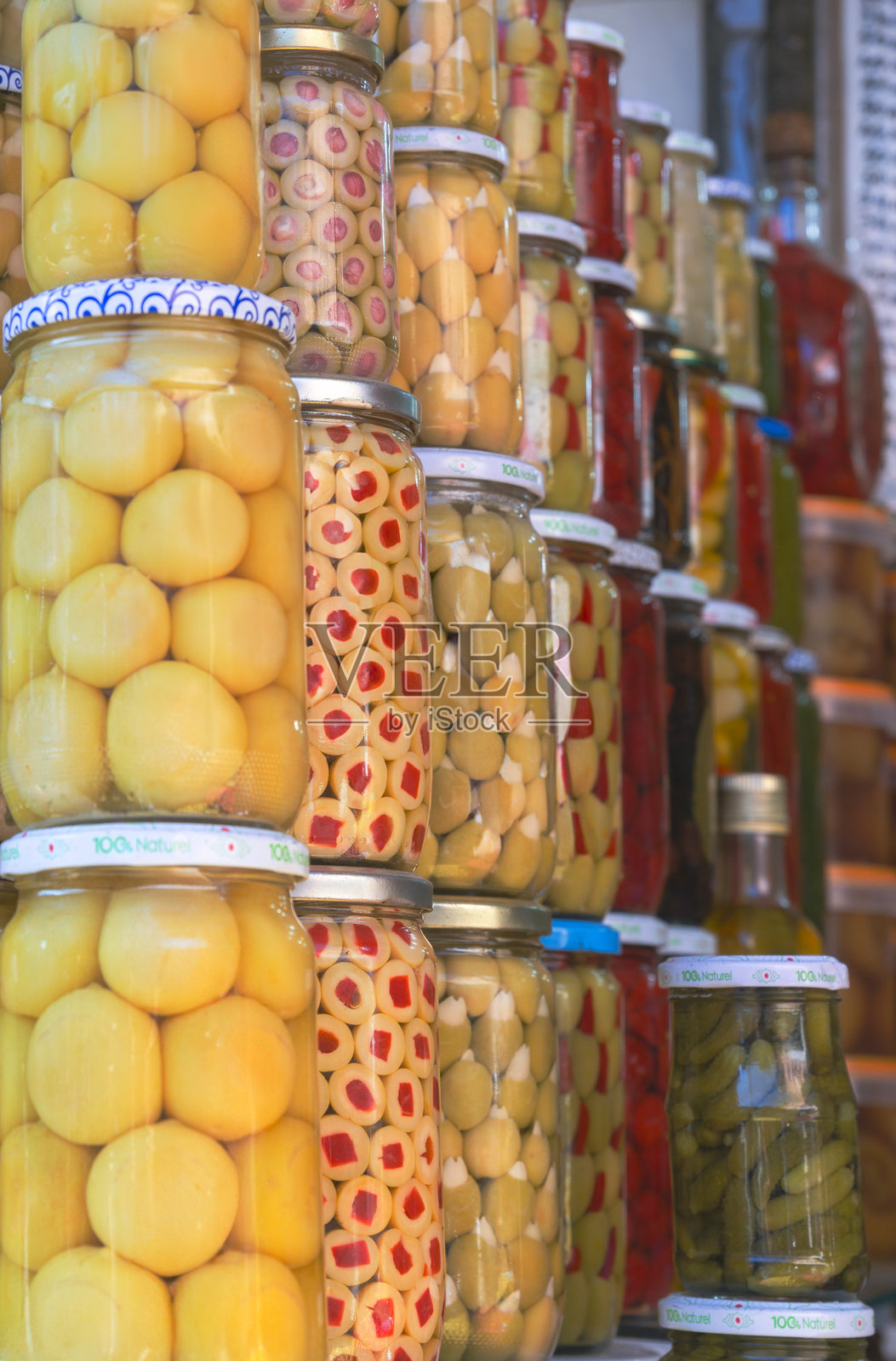 一排装有腌黄瓜和橄榄的罐子照片摄影图片