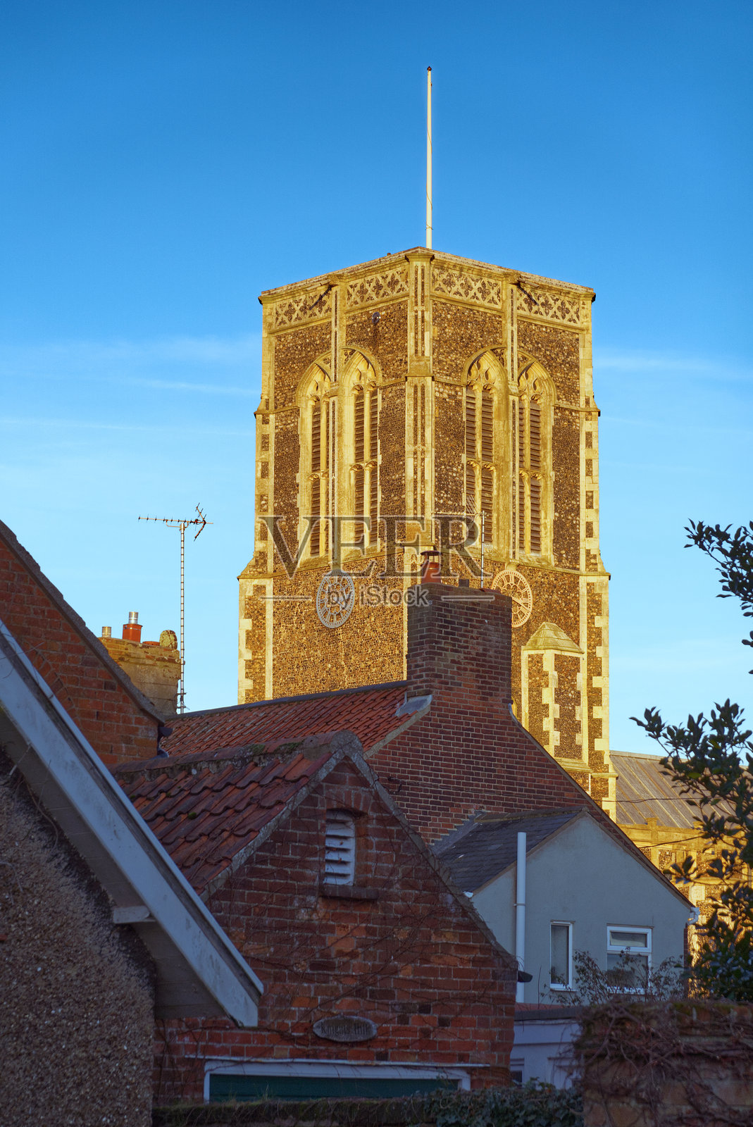 南沃尔德的圣埃德蒙德教堂 - 位于萨福克海滨小镇中心的历史悠久的教堂，被落日的金色光芒照亮照片摄影图片