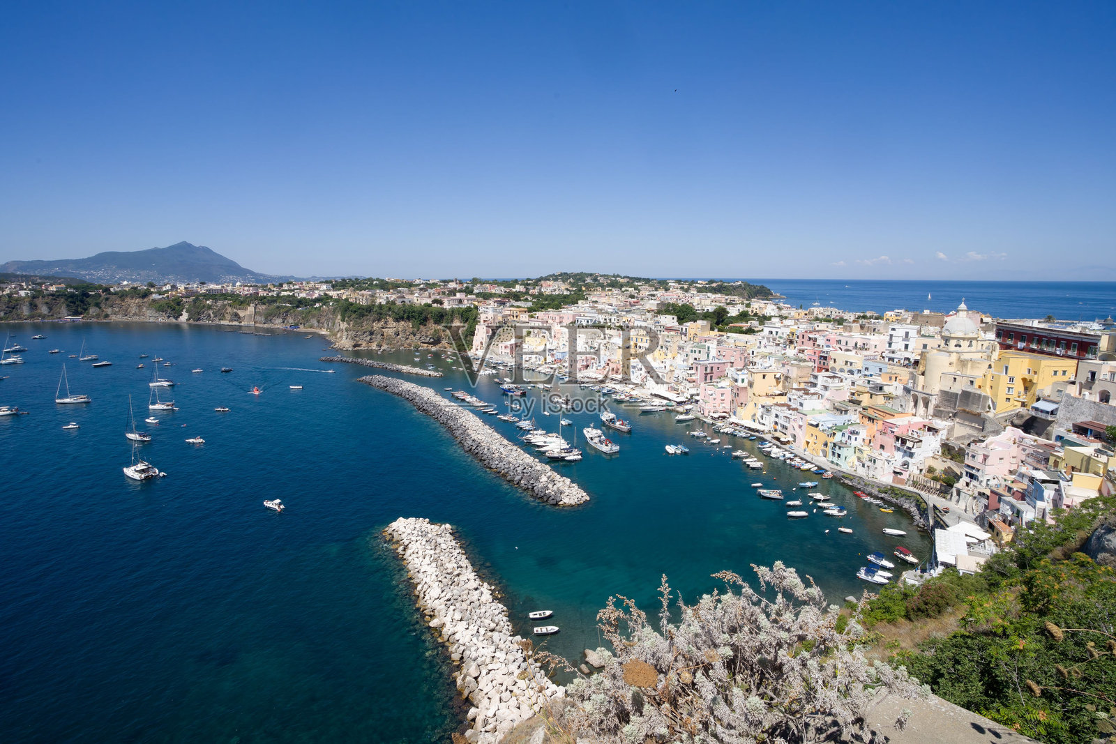 意大利那不勒斯的美丽景色，五彩斑斓的建筑、码头和清澈的蓝色海水照片摄影图片