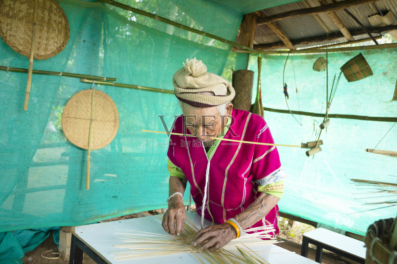 成熟的泰国男子在阳光保护下进行传统竹制工艺制作照片摄影图片