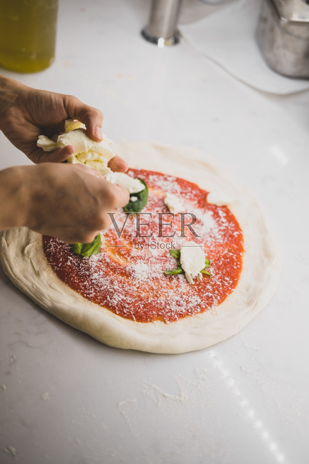 正宗意大利披萨在意大利餐厅手工制作时，使用新鲜的马苏里拉奶酪、番茄酱和配料。照片摄影图片