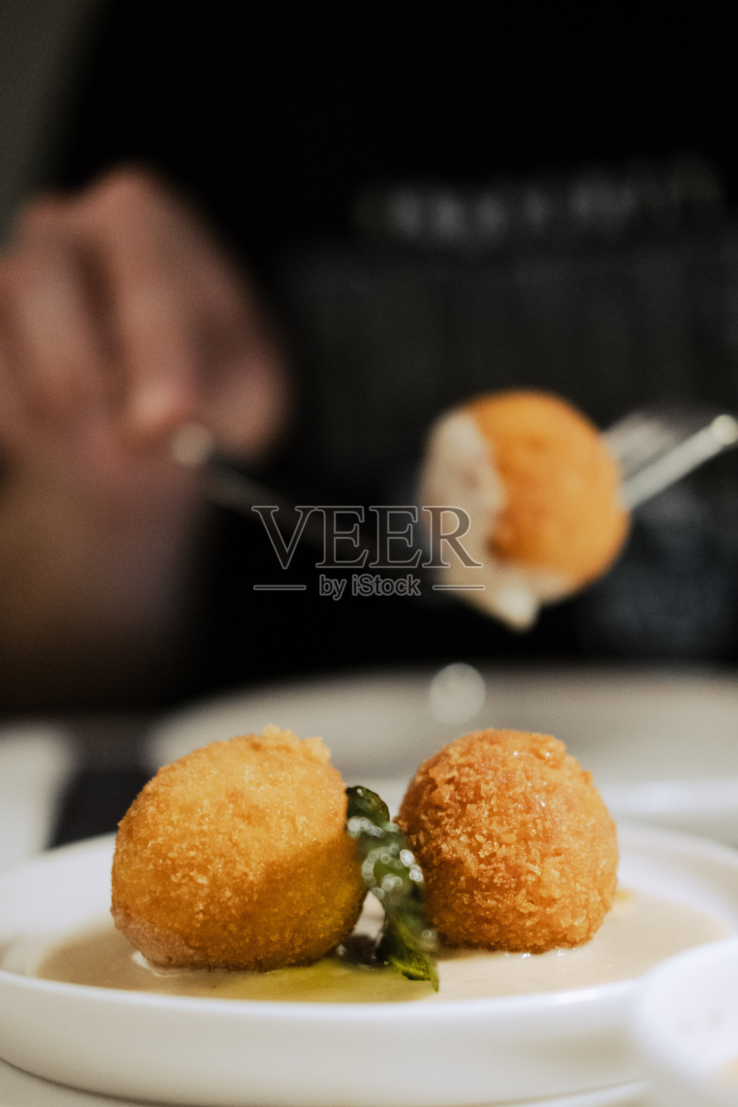 西西里阿兰奇尼米饭球，外脆金黄，搭配奶油帕尔马奶酪酱，在意大利餐厅呈现照片摄影图片