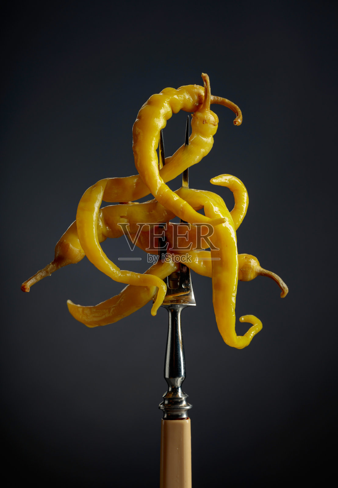 黑色背景上的罐装黄椒。照片摄影图片