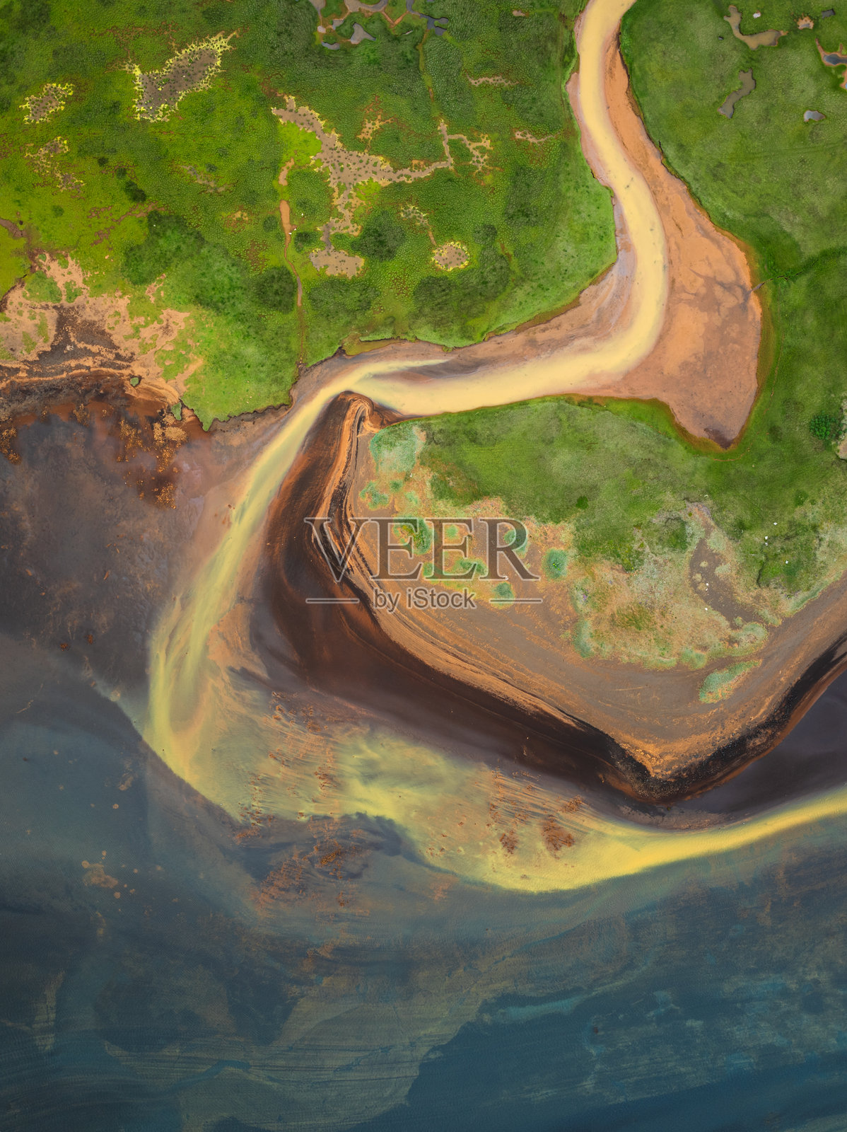 南冰岛奥尔夫萨河的彩色沉积物图案和郁郁葱葱的河岸的鸟瞰图照片摄影图片