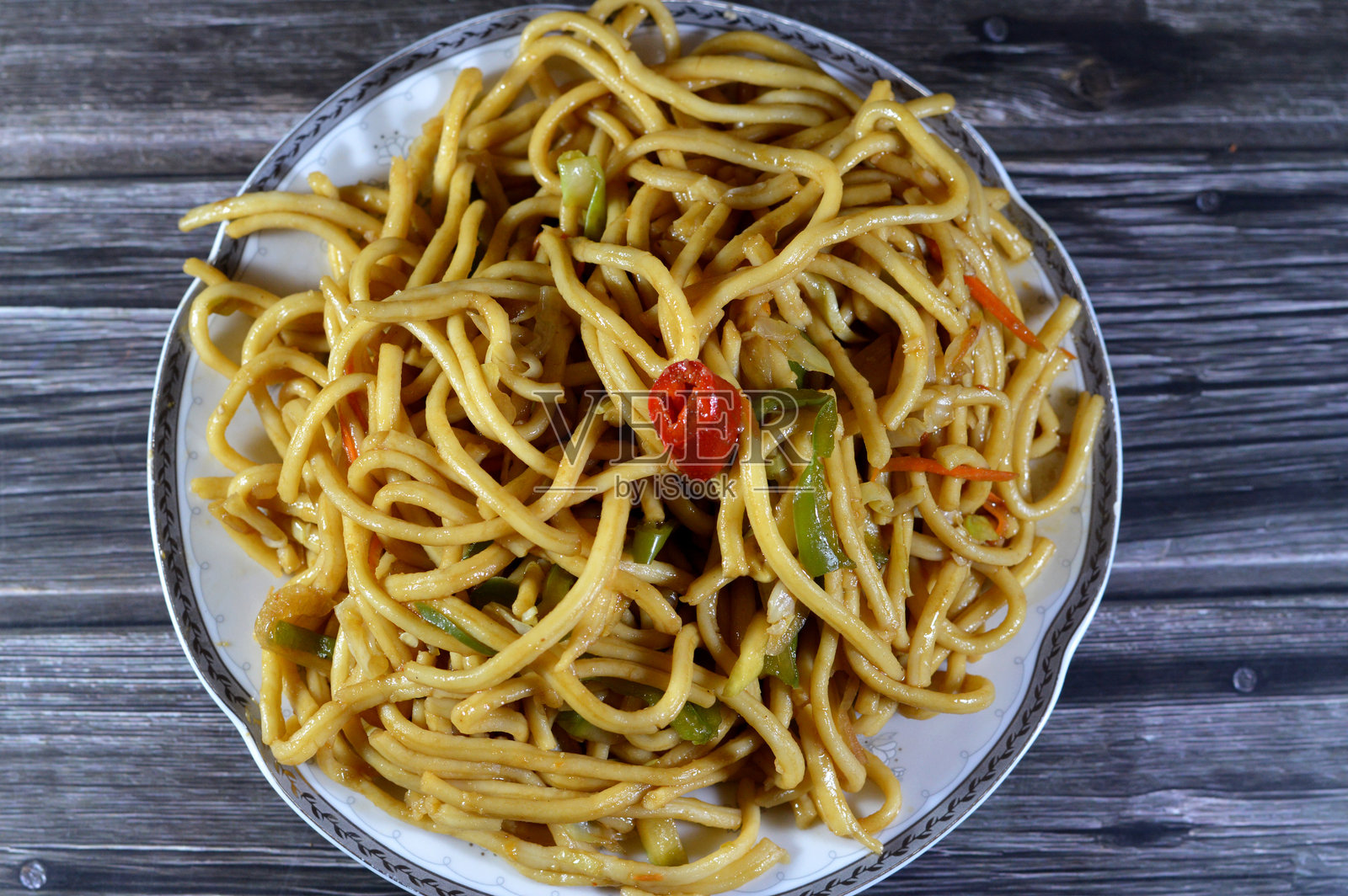 传统中式面条，配有洋葱、酱油和香料、甜椒和辣椒，通常与甜酸鸡或辣鸡一起食用。照片摄影图片