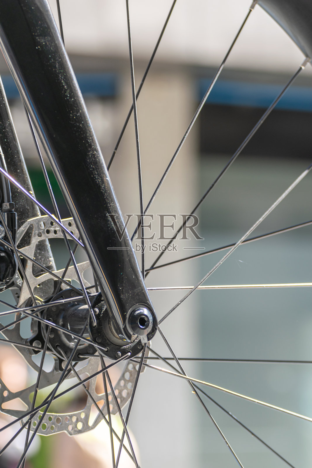 竞赛公路自行车前轮的部分视图，背景为轮辐和制动系统，适合骑行概念。照片摄影图片