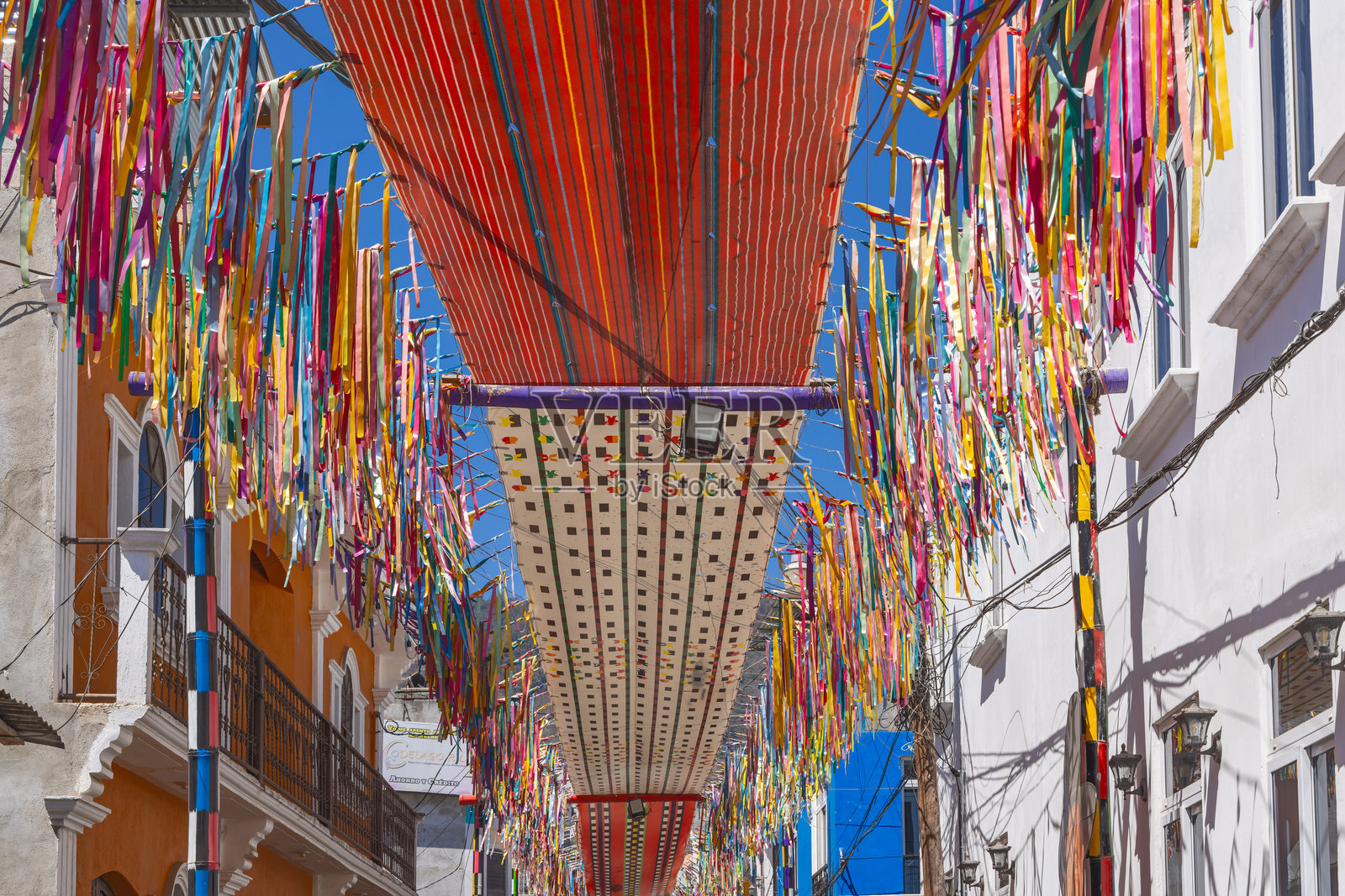 在危地马拉圣胡安拉拉古纳街道上悬挂的五彩布条。照片摄影图片