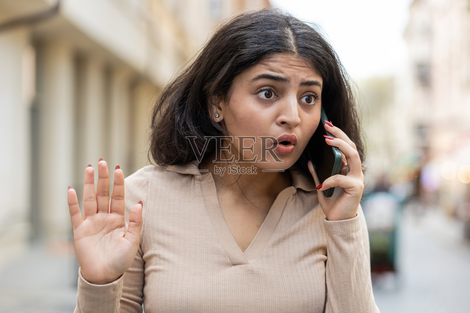 愤怒、烦躁、压力大的印度年轻女性在手机上争吵，激动地大声争论照片摄影图片