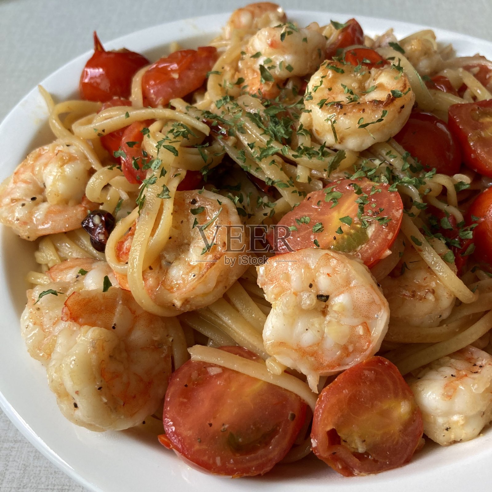 一盘完美煮熟的意大利面，上面浇有浓郁的番茄酱和新鲜的香草。非常适合食品摄影和菜单，生动展现意大利美食的魅力。照片摄影图片