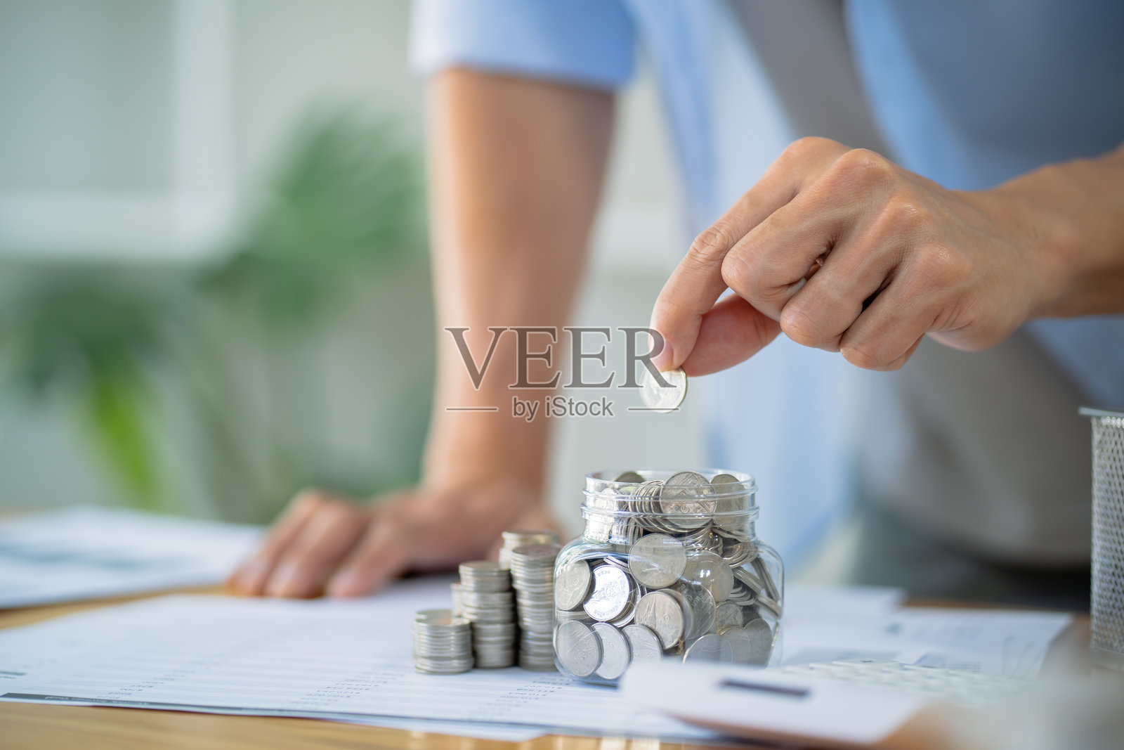 节省资金。商人会计师核实不断增长的业务和通过堆叠硬币来节省资金，使用计算器。会计概念。照片摄影图片