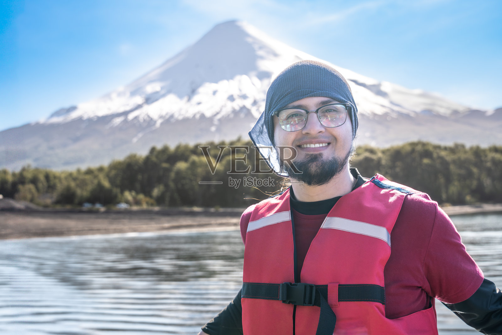 年轻的拉丁旅行者在智利，背后是奥索尔诺火山。智利旅行者。湖区。巴塔哥尼亚。照片摄影图片