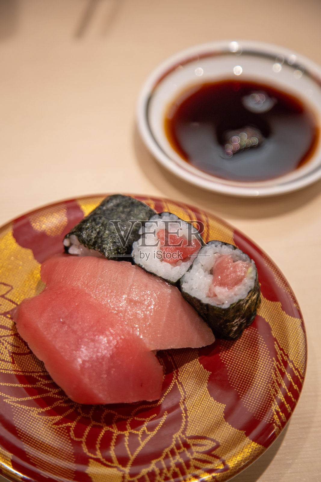 京都寿司餐厅的日本美食，跑寿司盘上摆放着精选的金枪鱼卷和握寿司。照片摄影图片