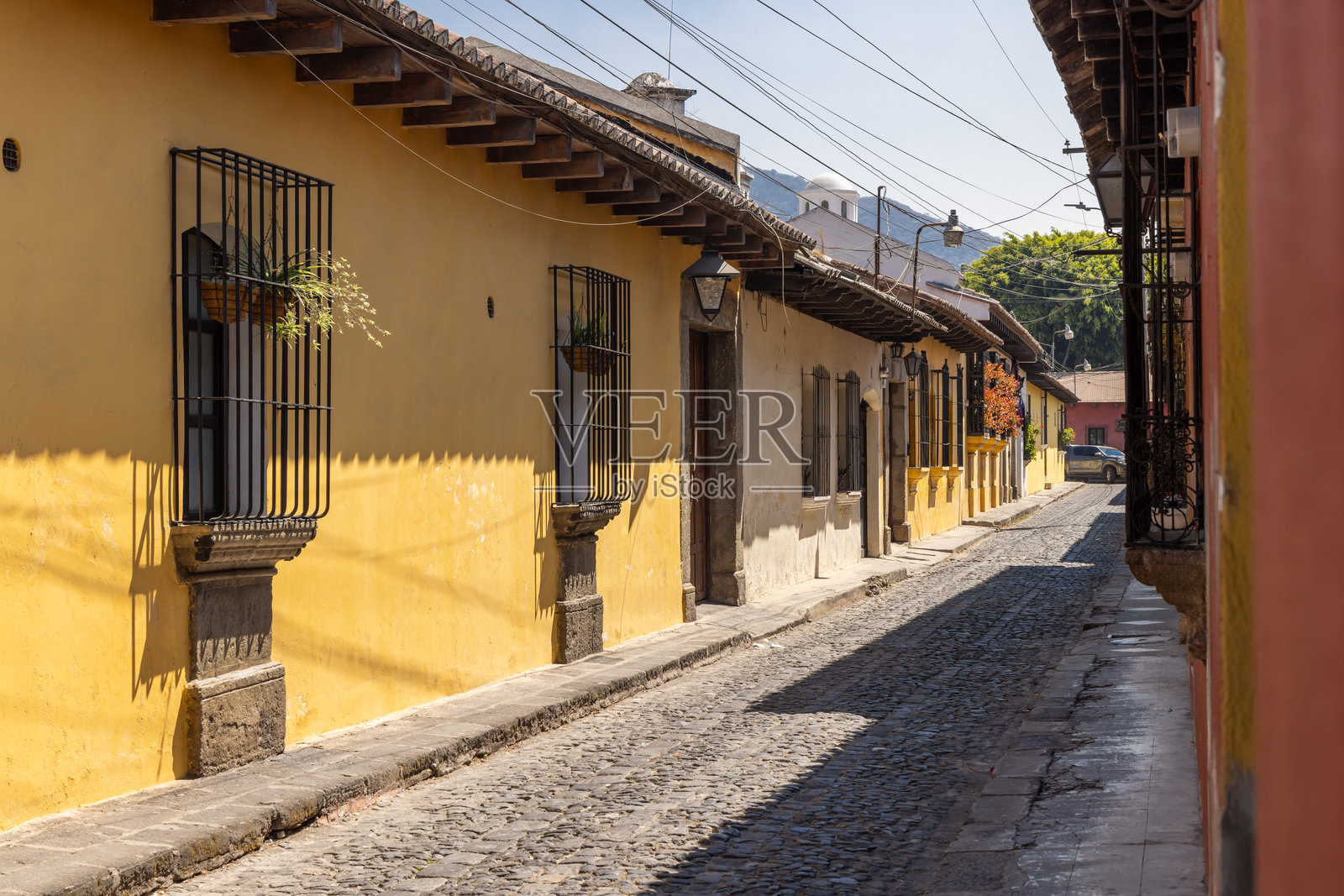 安提瓜瓜地马拉的一条狭窄的鹅卵石街道。照片摄影图片