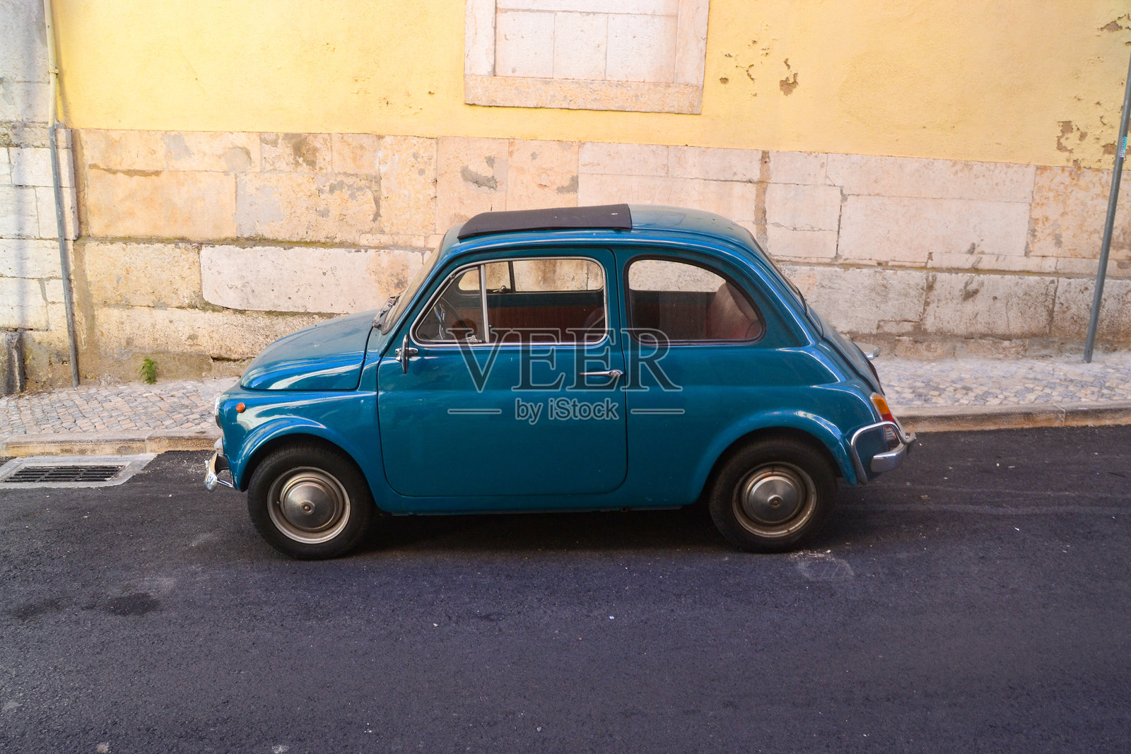 复古菲亚特汽车停靠在古老建筑的墙边照片摄影图片