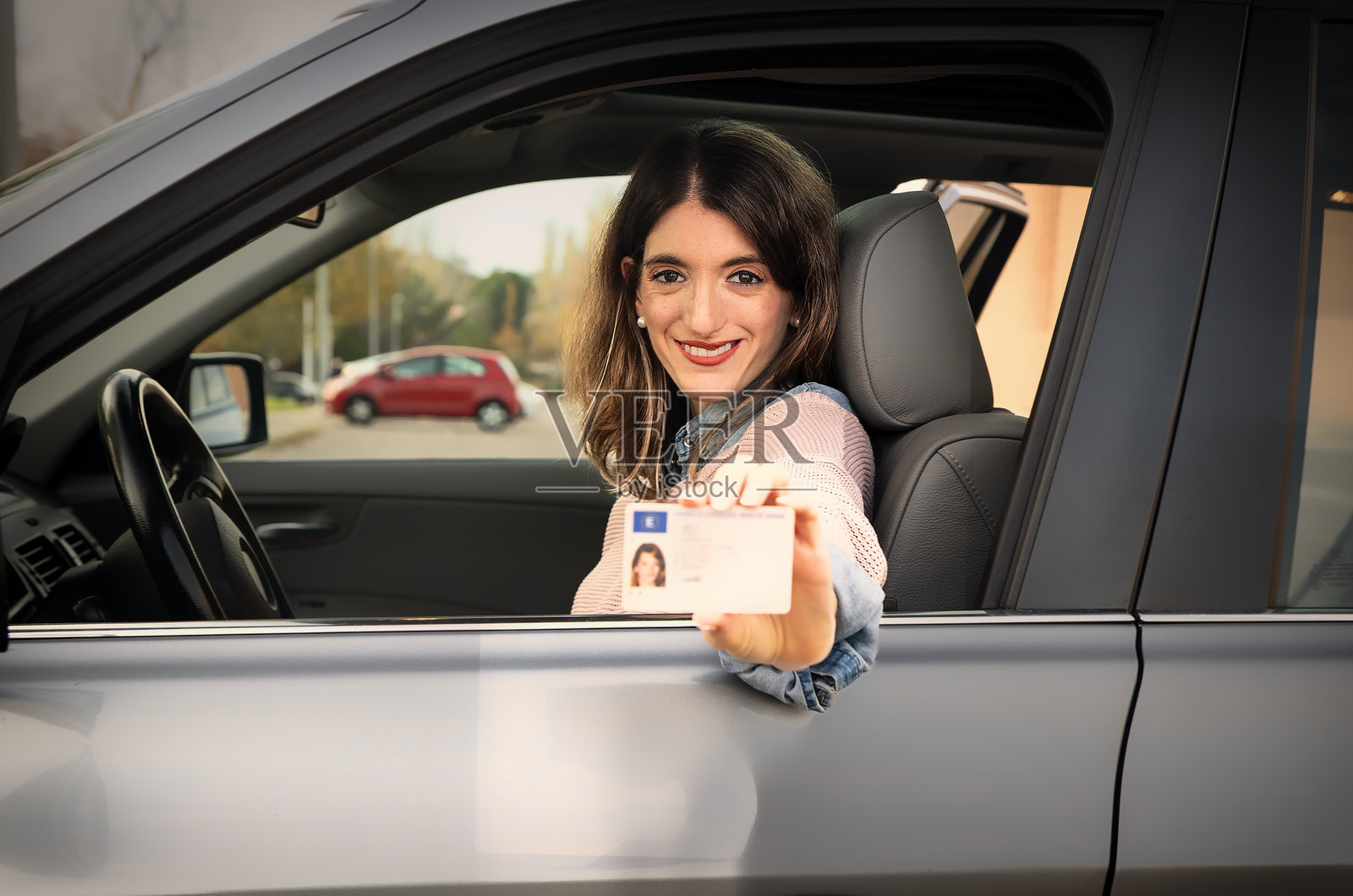 年轻女性在车内展示驾照照片摄影图片