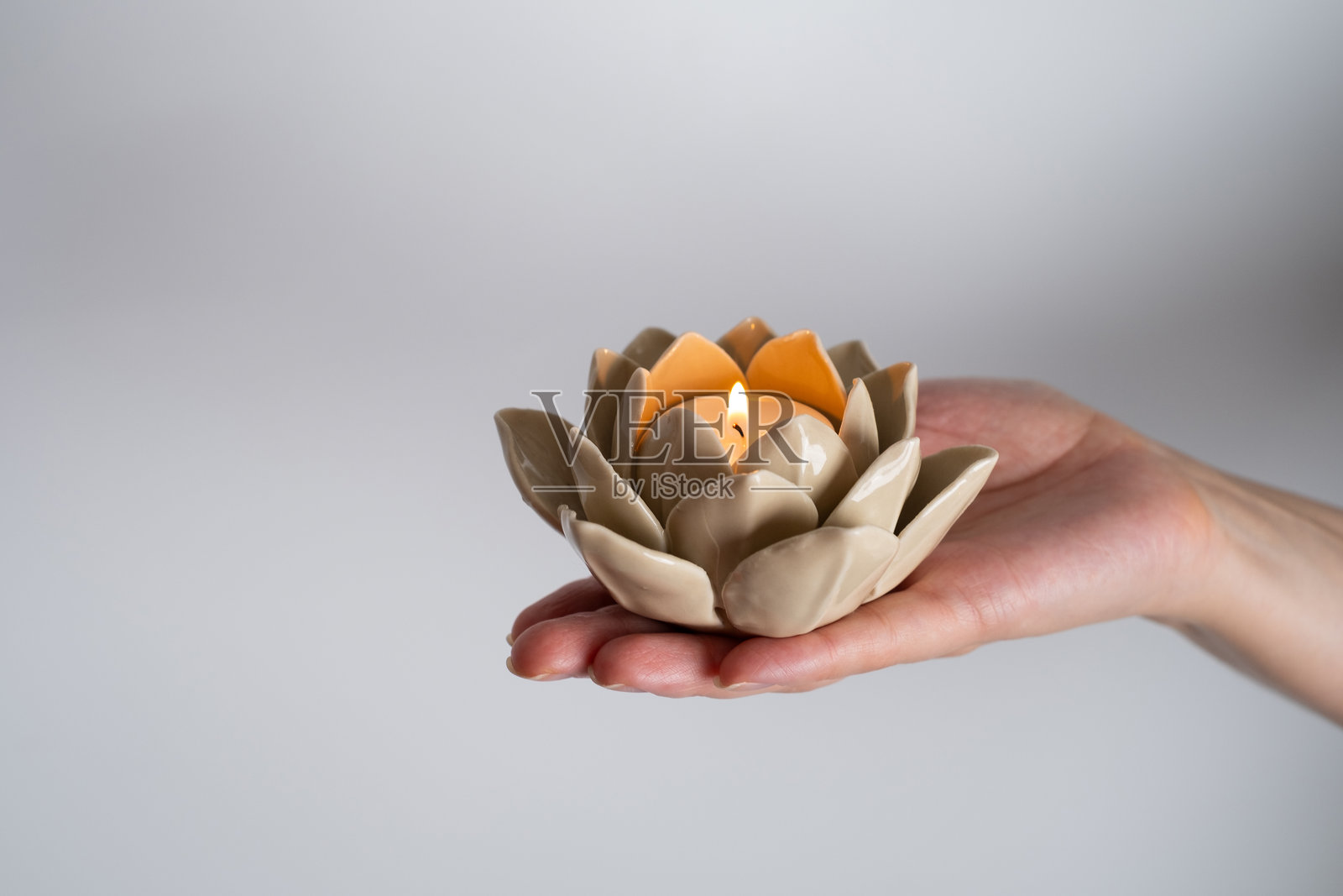 女人手中燃烧的莲花形蜡烛。和谐的概念照片摄影图片