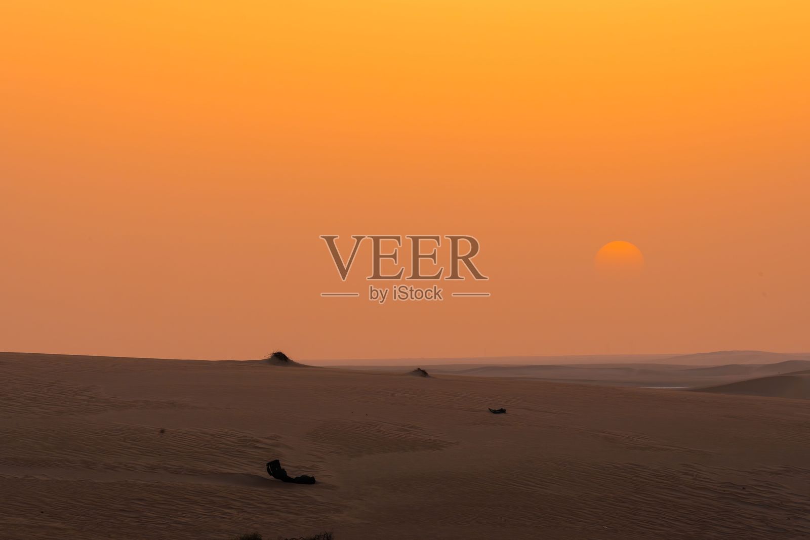 沙漠日落，橙色天空与沙丘。照片摄影图片