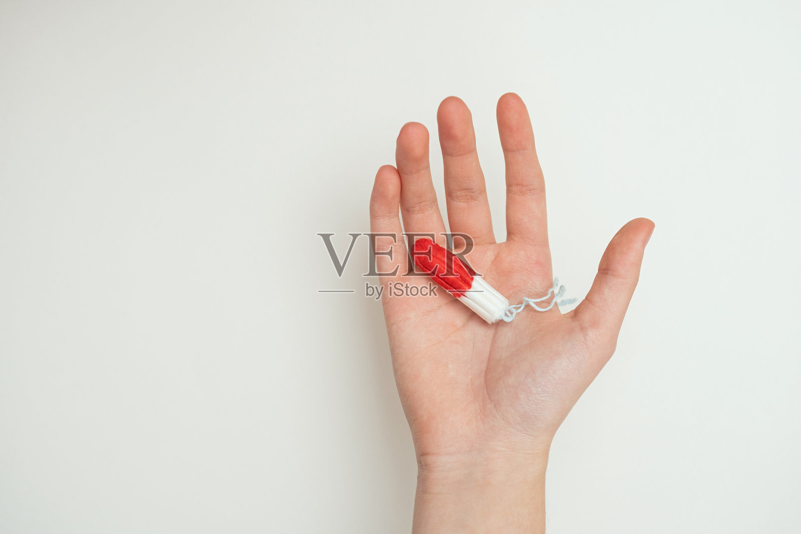 一位年轻女性的手握着一个卫生棉条照片摄影图片