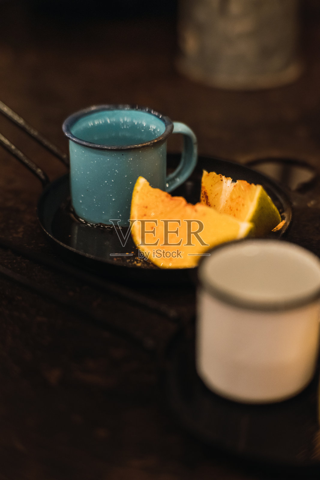 在锡杯中盛放的梅斯卡尔酒，旁边配有橙子和虫盐。照片摄影图片