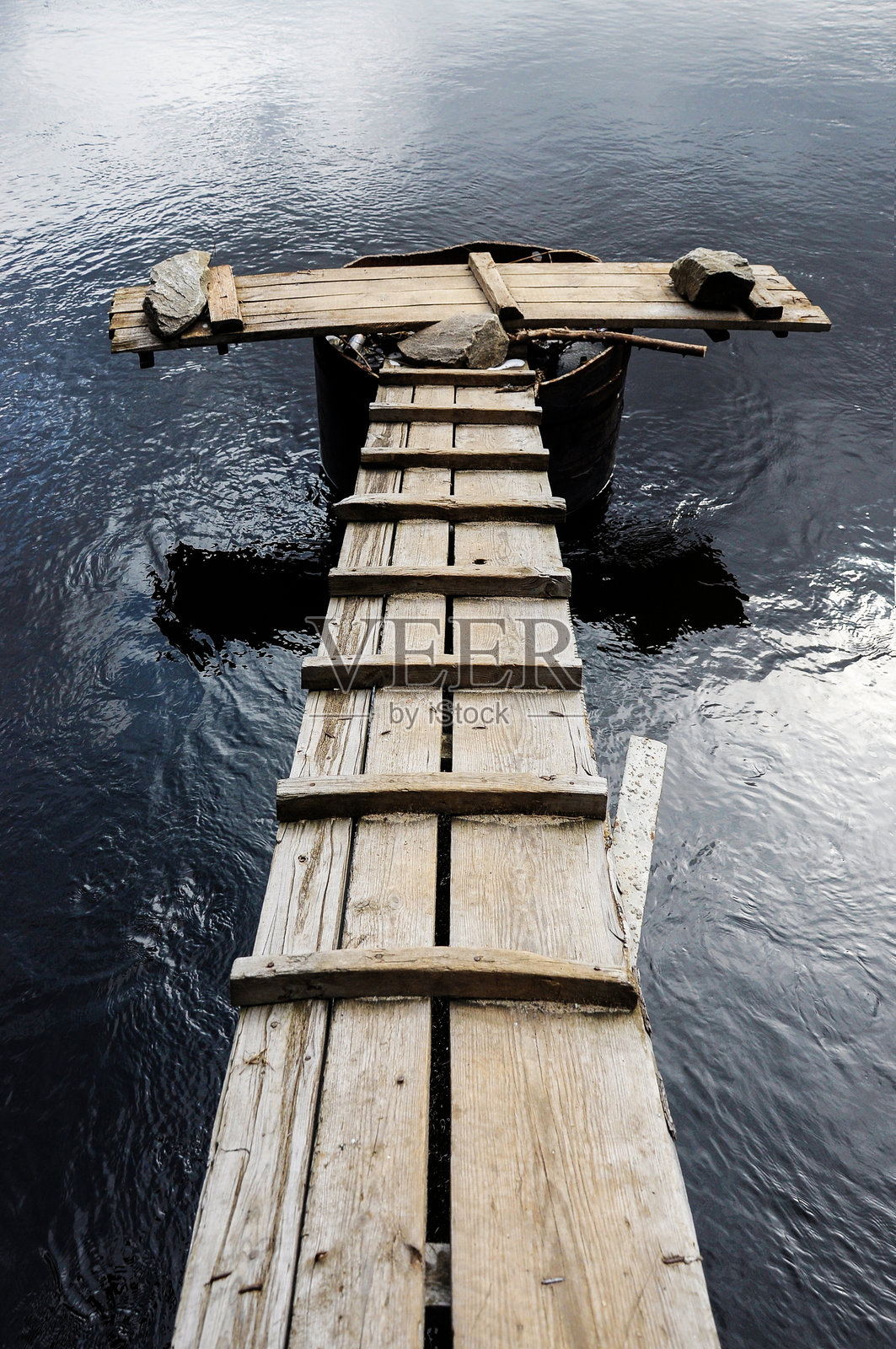 木板和石头搭建的河上桥梁照片摄影图片