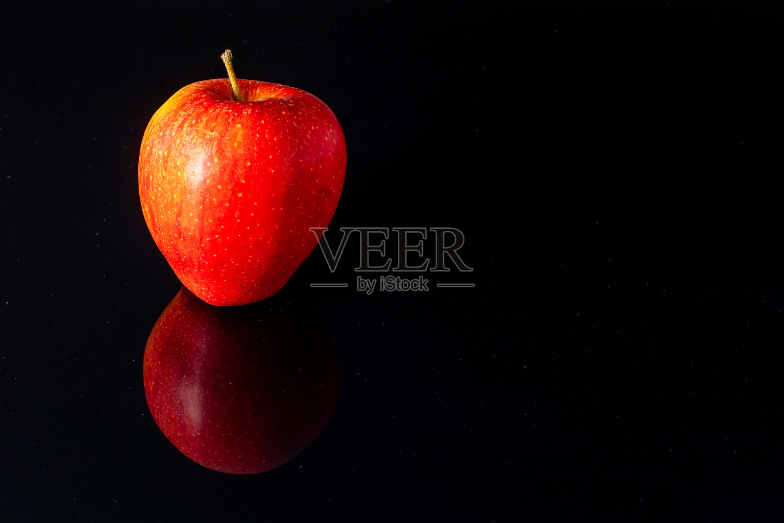 黑色镜面背景上的红苹果特写照片摄影图片