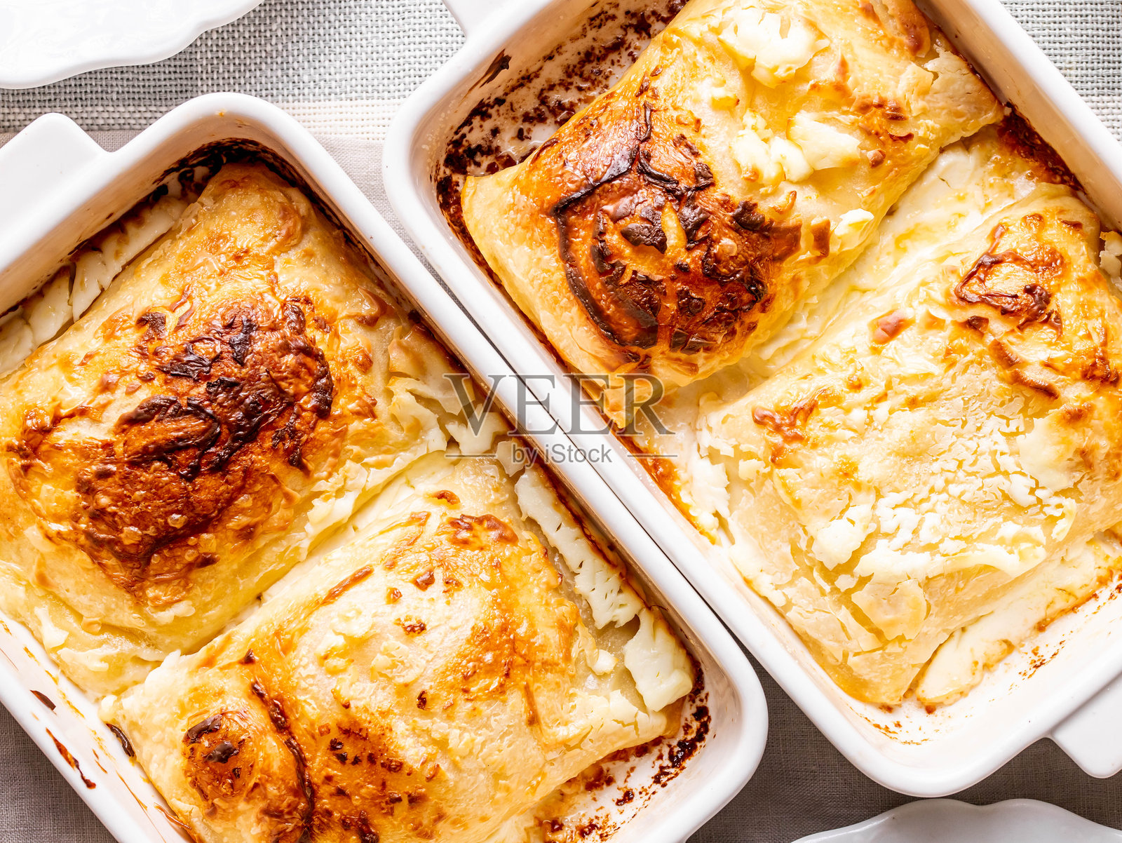 从上方俯视的扎戈尔斯基奶酪饺子，分成两个独立的盘子烘烤而成照片摄影图片