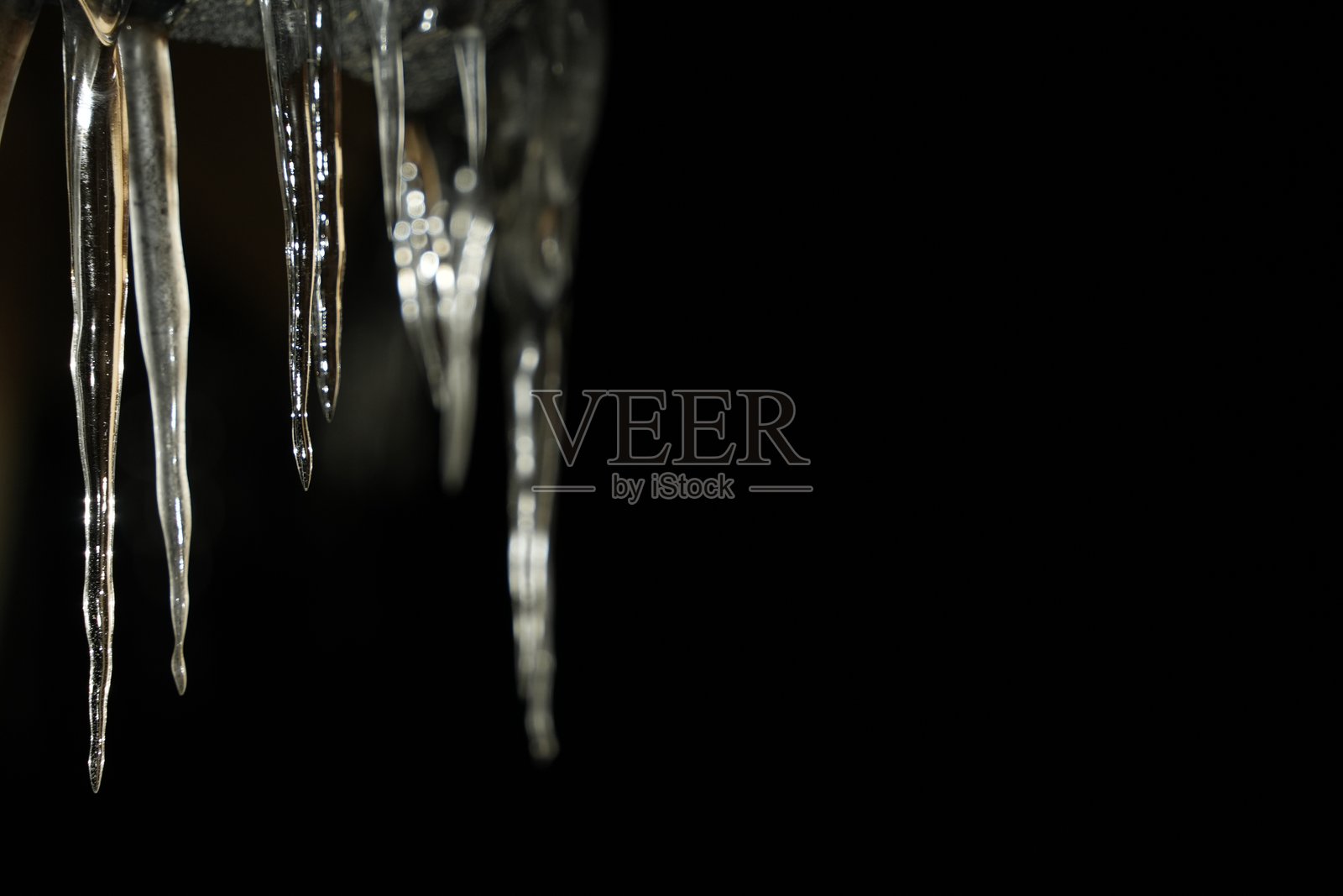 芬兰拉普兰的科塔小屋外，寒冷冰冷的冬夜里挂满了冰柱。照片摄影图片