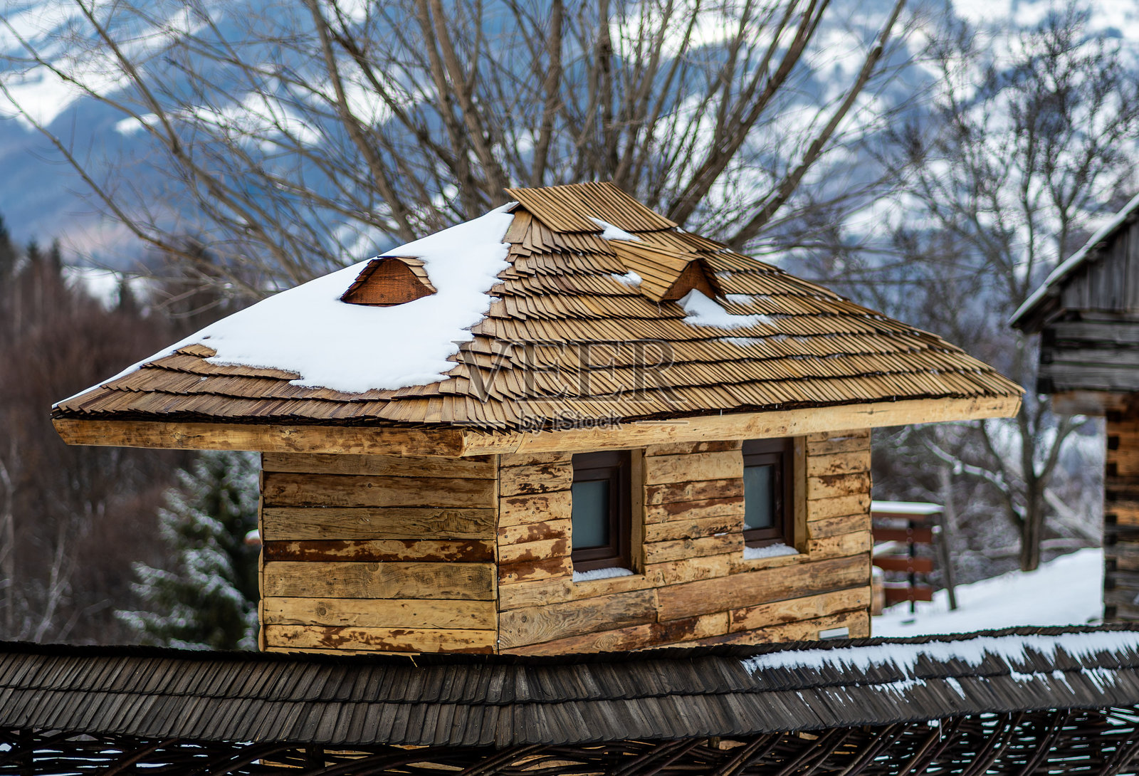 宁静冬季景观中的乡村木屋，屋顶覆盖着白雪照片摄影图片