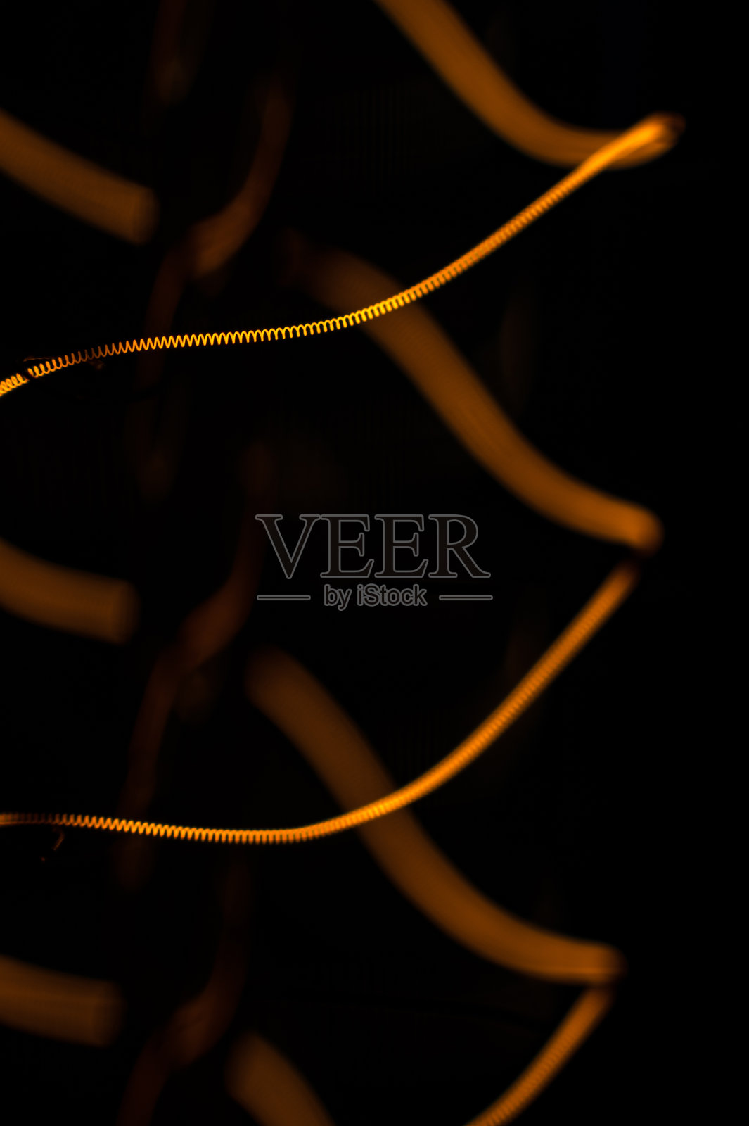 黑色背景下爱迪生灯泡的闪亮灯丝，微距拍摄照片摄影图片