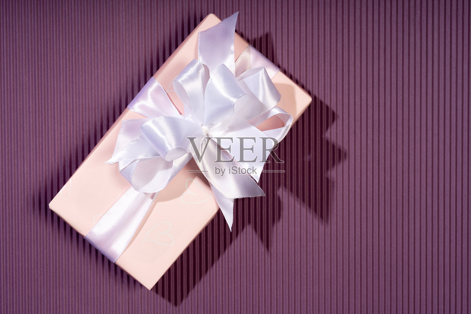 女性手握着礼品盒，背景明亮。适合圣诞节、情人节和生日的礼物。美丽的节日背景。照片摄影图片