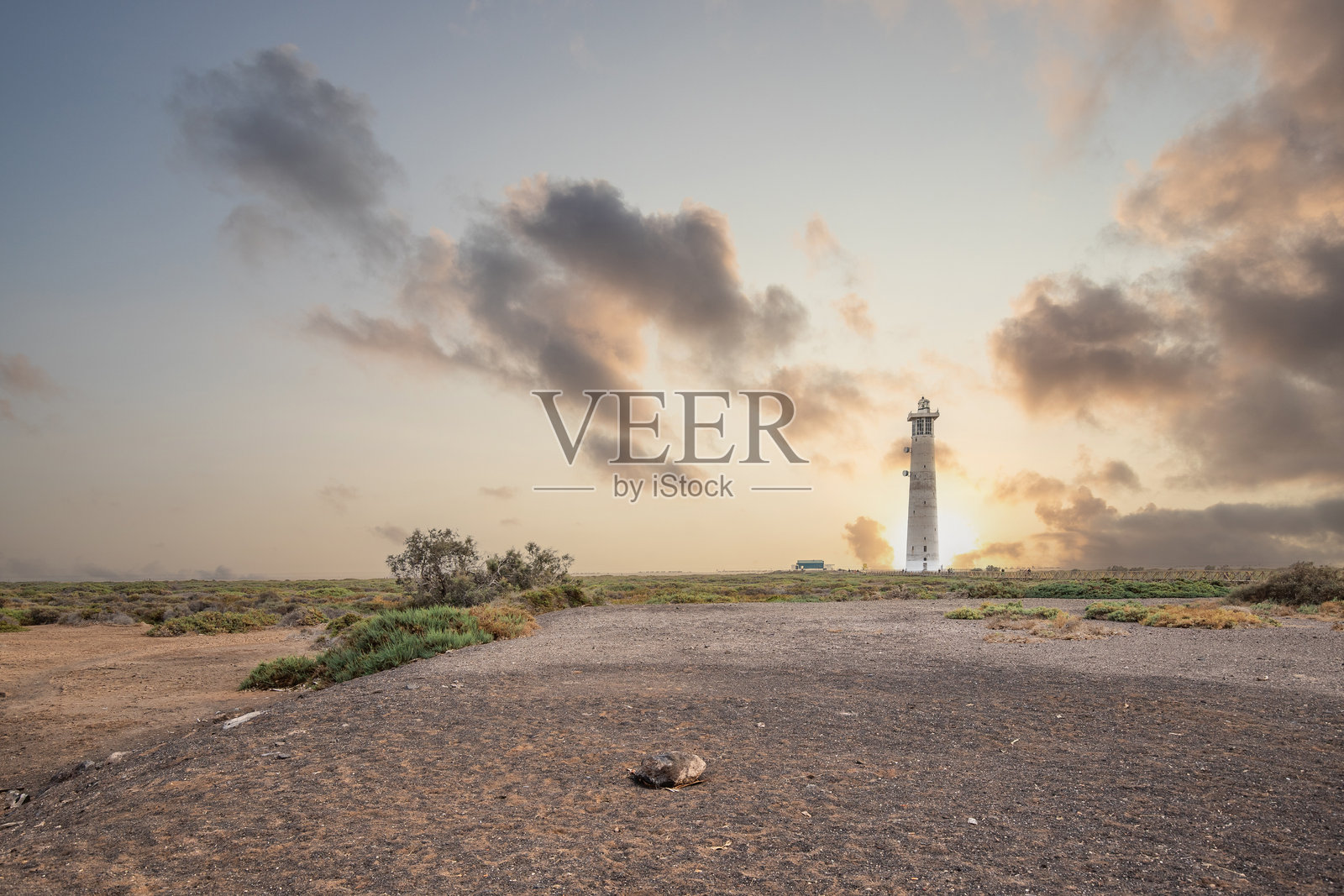 自然保护区日落时的灯塔。在摩罗哈布尔，富埃特文图拉，加那利群岛，西班牙的轻微沙尘暴中灯塔。照片摄影图片