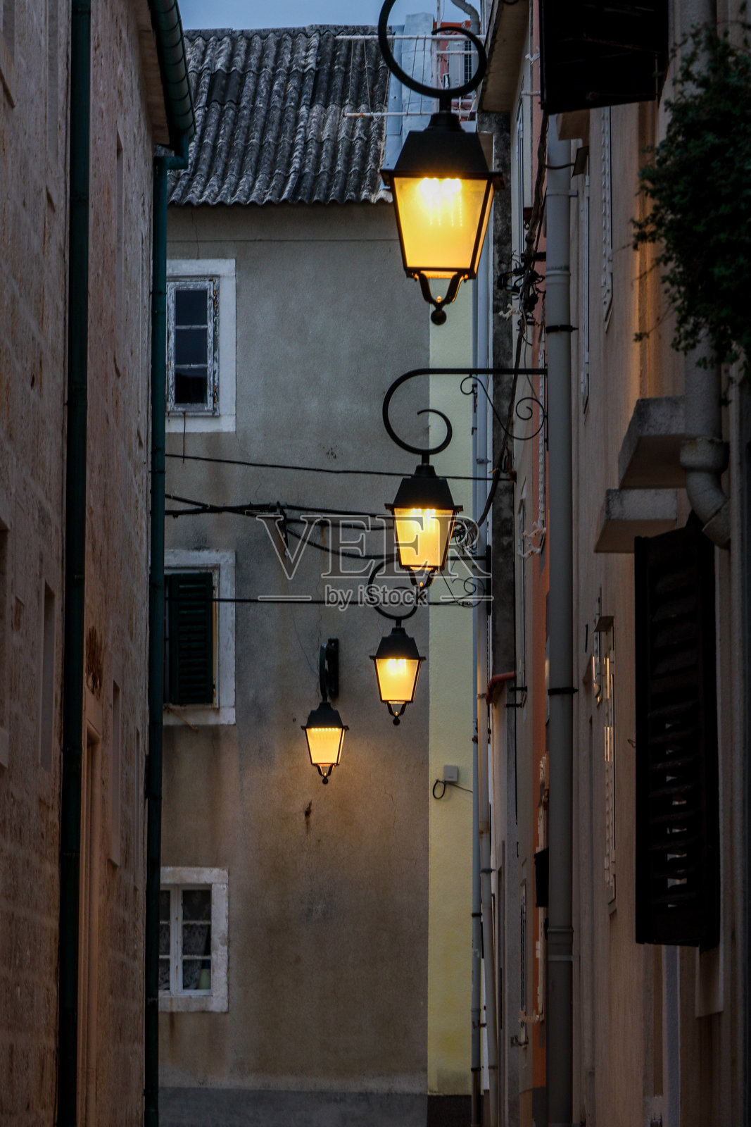 空荡荡的古老小巷，黄昏时分的街灯映衬着历史氛围。竖版照片照片摄影图片