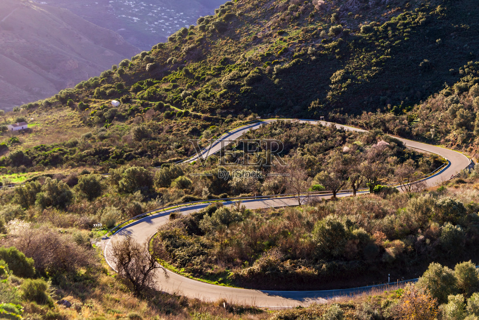 蜿蜒的山路，S型曲线克服陡坡，路面曲折且弯道非常紧凑。照片摄影图片