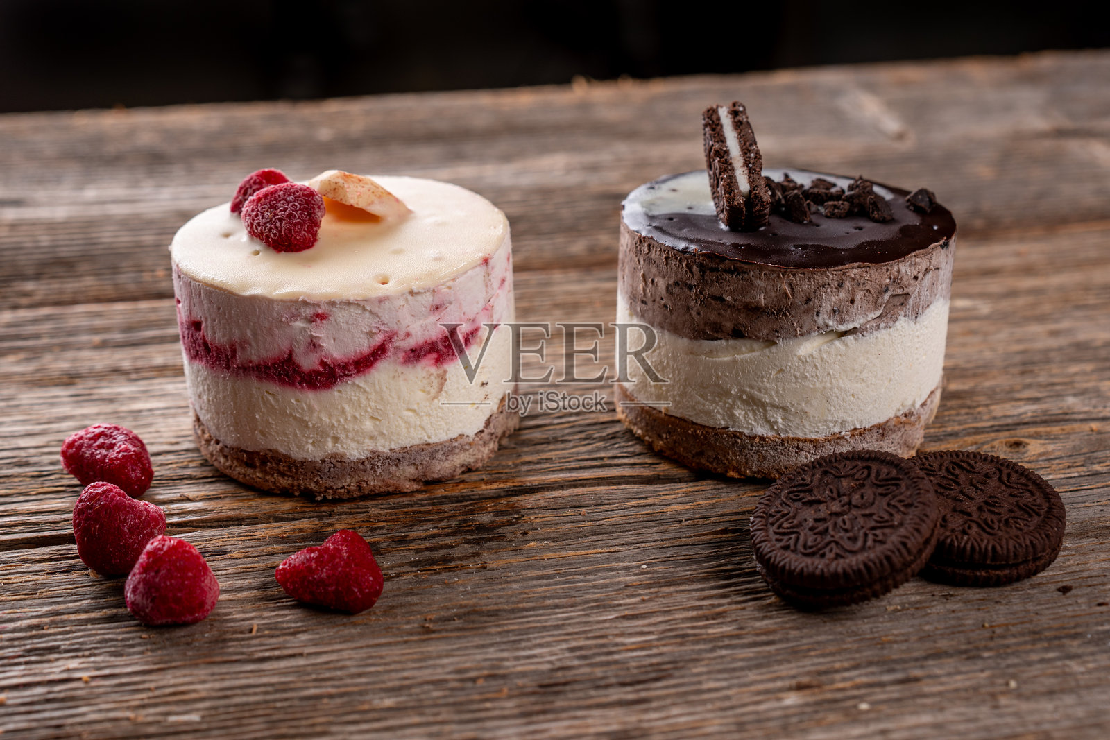 迷你覆盆子巧克力芝士蛋糕，饼干底，放在乡村风格的木桌上照片摄影图片