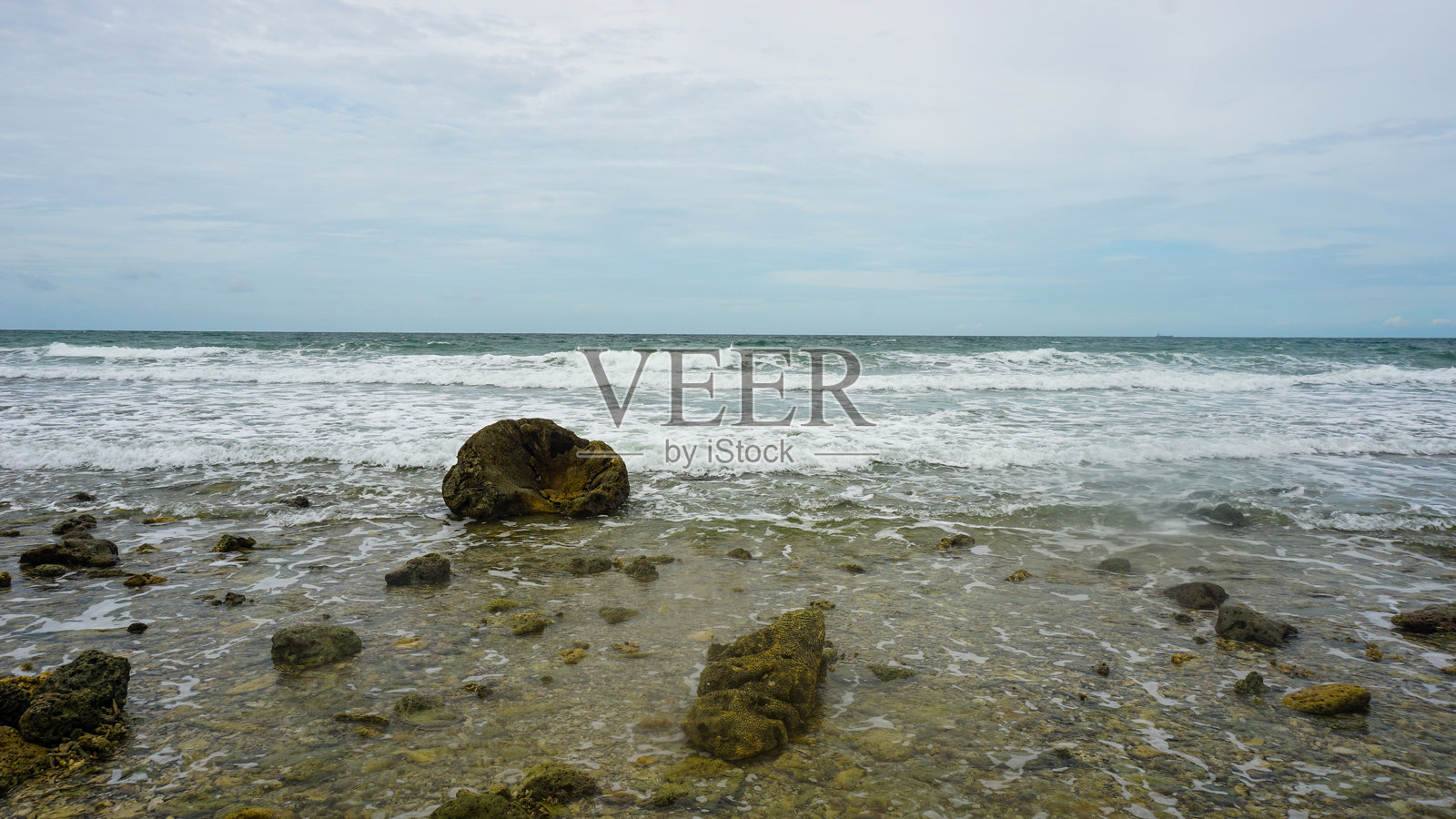 宁静的海滩，轻柔的海浪和岩石海岸线照片摄影图片