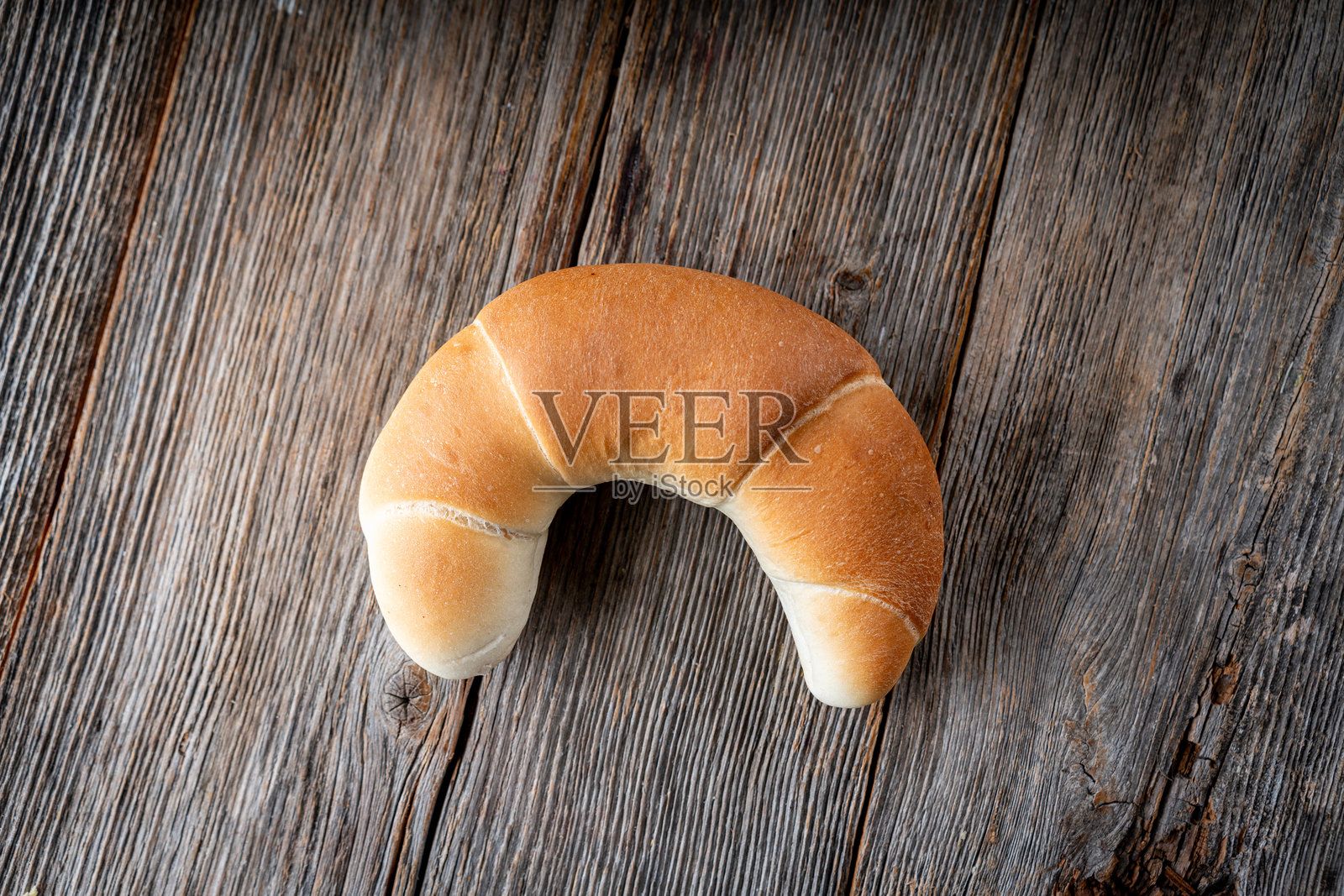 金色新月面包卷放在粗糙的木头上照片摄影图片