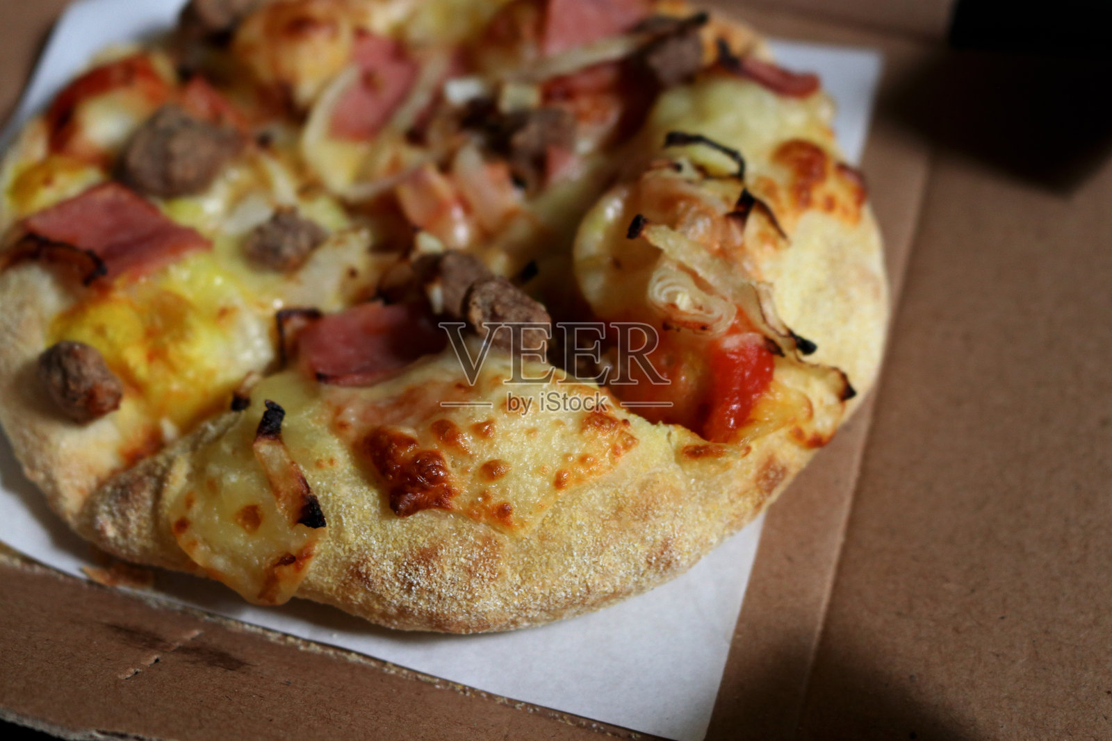 美味的比萨饼切片，上面配有牛肉、奶酪、香肠和辣酱照片摄影图片