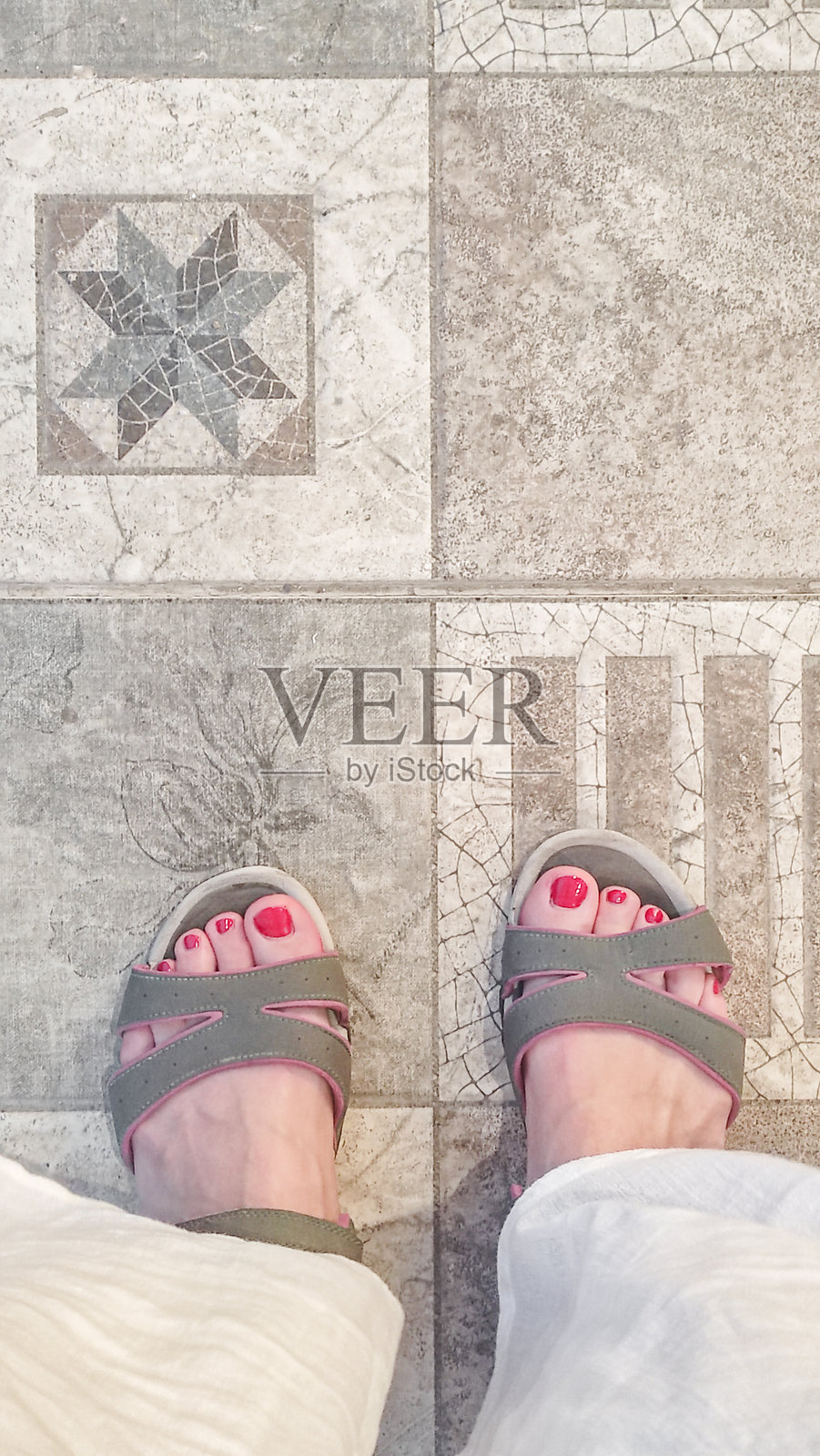 游客穿着凉鞋，站在埃及水疗后装饰性陶瓷砖上。照片摄影图片