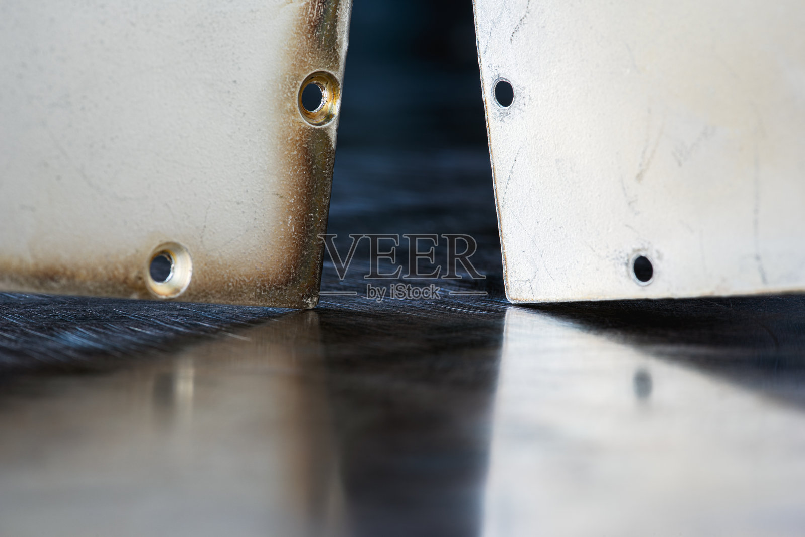 悬挂在反光表面上带孔的钢板照片摄影图片