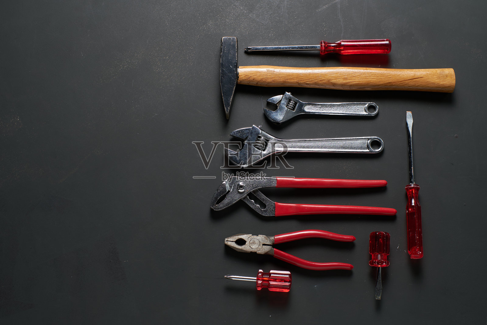 整齐排列在黑色表面上的手工具集合照片摄影图片