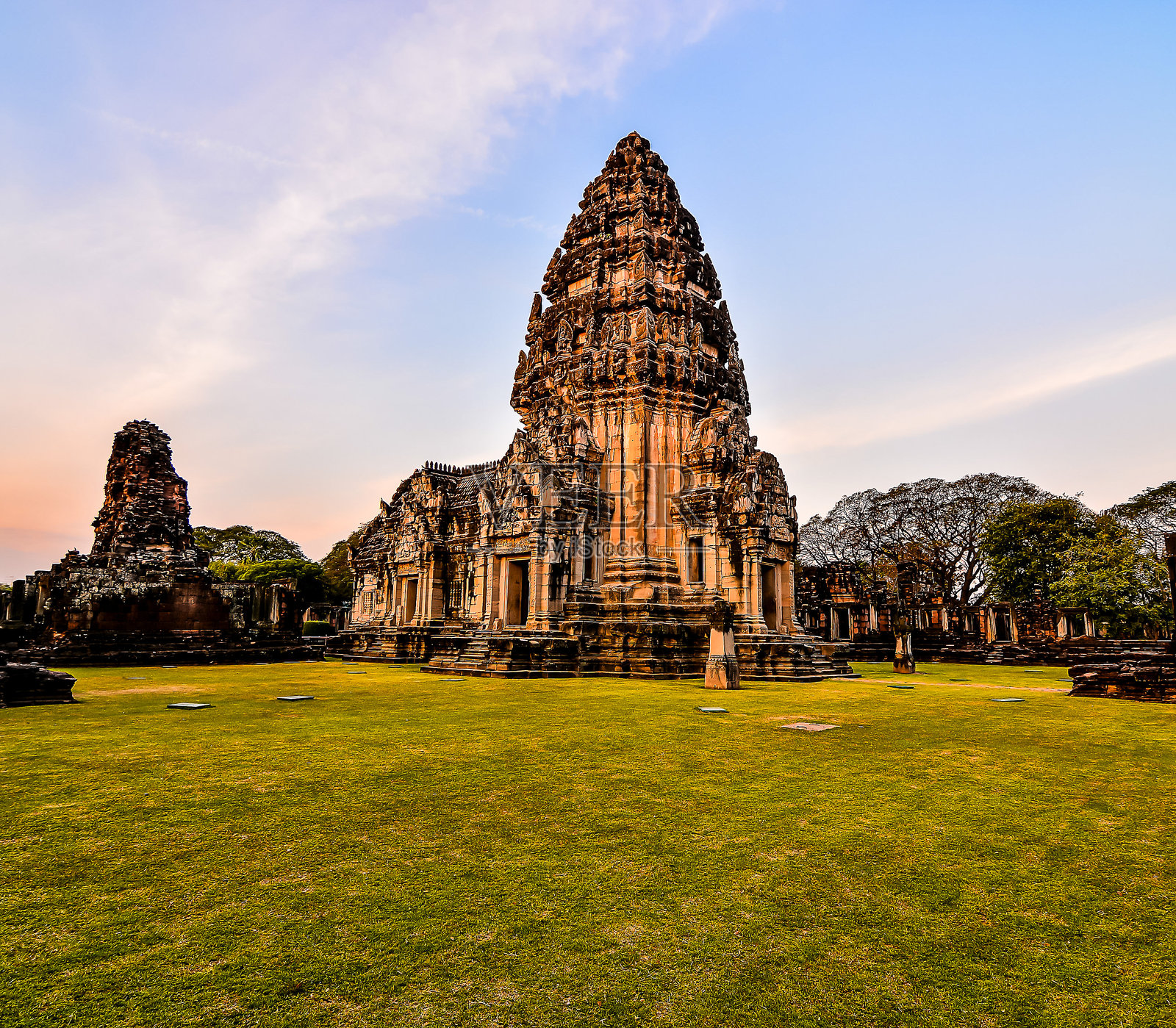 一座带尖塔的大楼坐落在草地上照片摄影图片