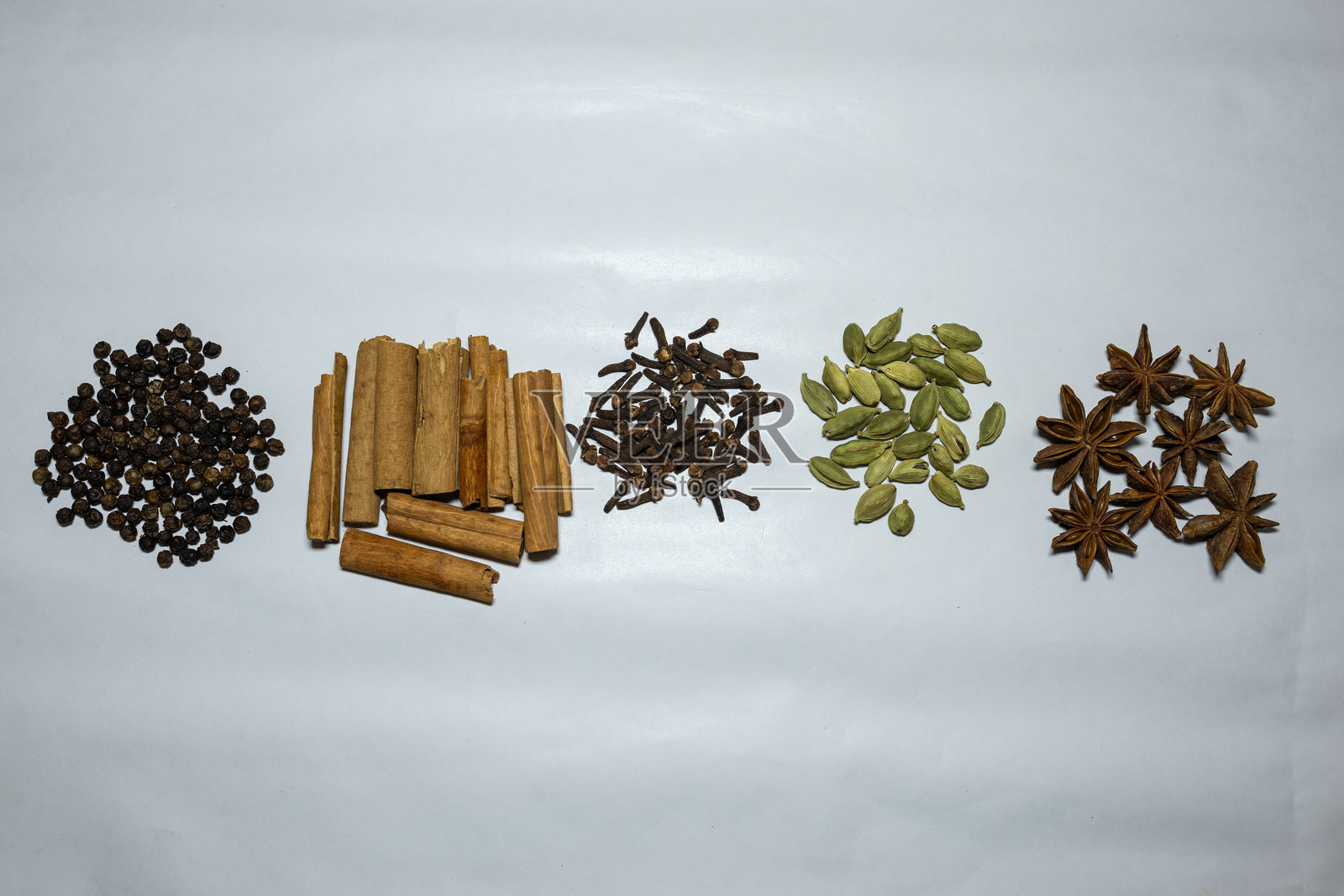 新鲜生丁香、黑胡椒、豆蔻、八角和肉桂棒在白色背景上照片摄影图片