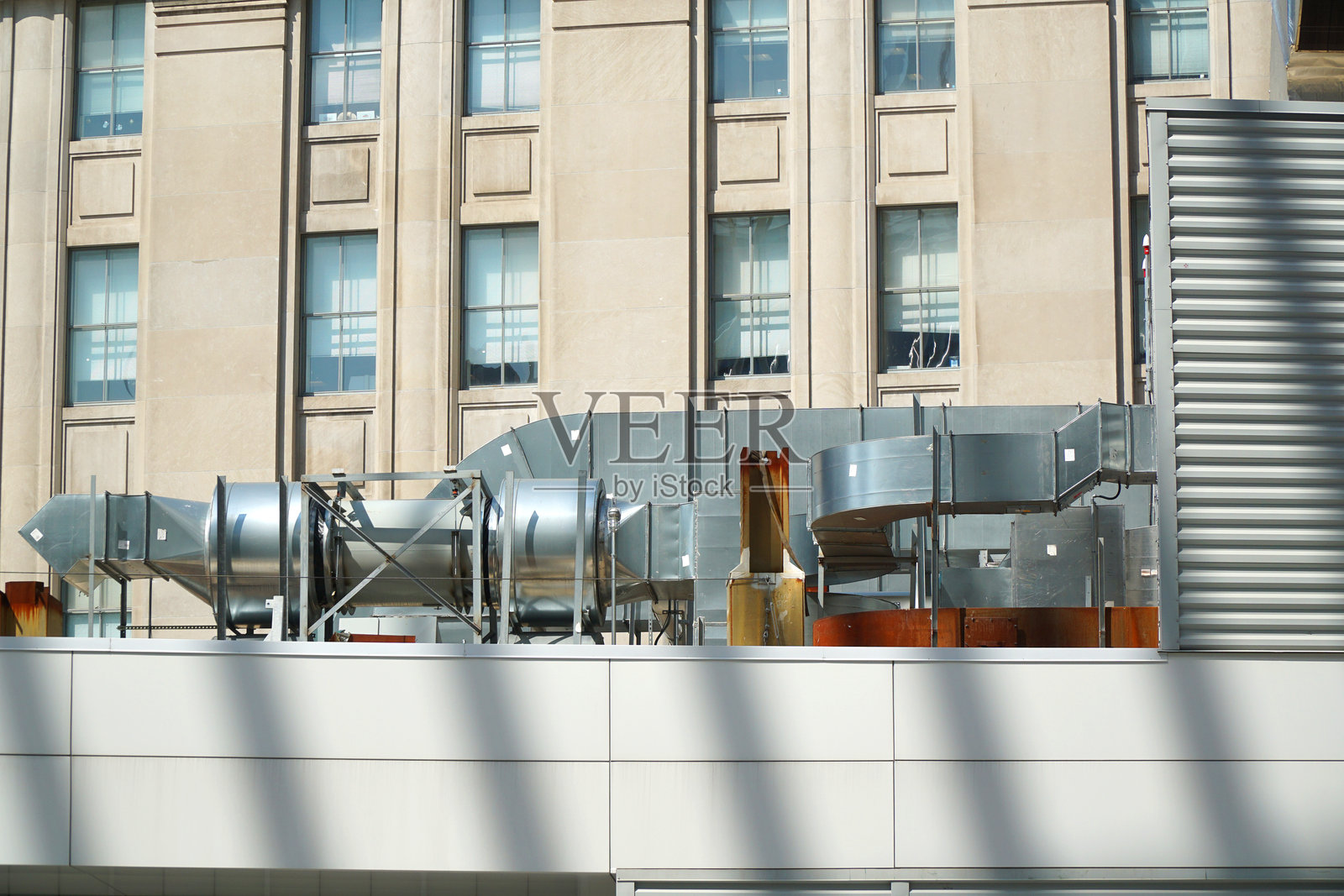 建筑外部屋顶上安装的空调管道照片摄影图片