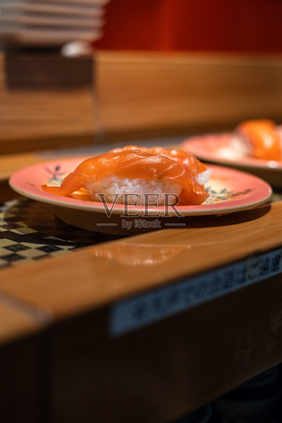 东京寿司餐厅的日本美食，跑寿司盘上有金枪鱼握寿司和三文鱼虾卷。照片摄影图片