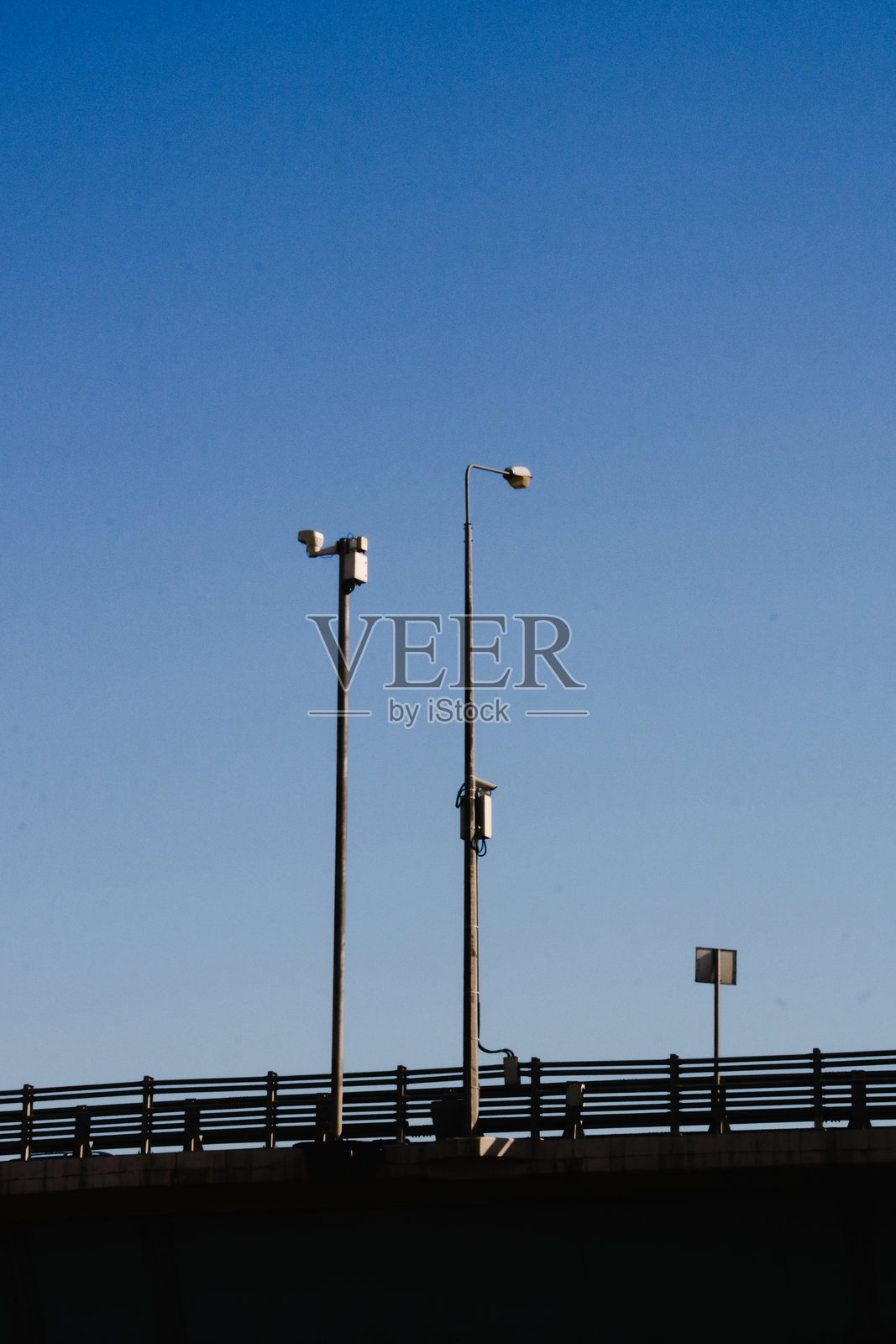 汽车桥。带警告系统的灯柱。蓝天上的街灯。照片摄影图片