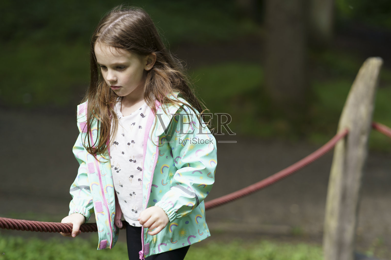 小女孩露出微笑，缺了一颗牙，在游乐场玩耍。快乐的童年概念照片摄影图片