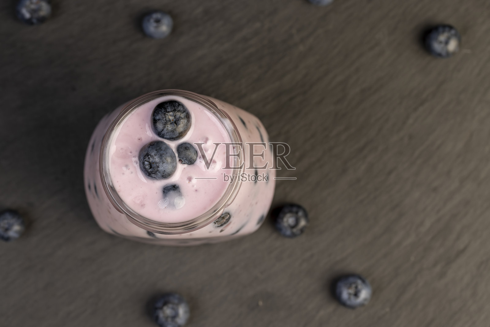 蓝莓酸奶，配有切片和整颗蓝莓照片摄影图片