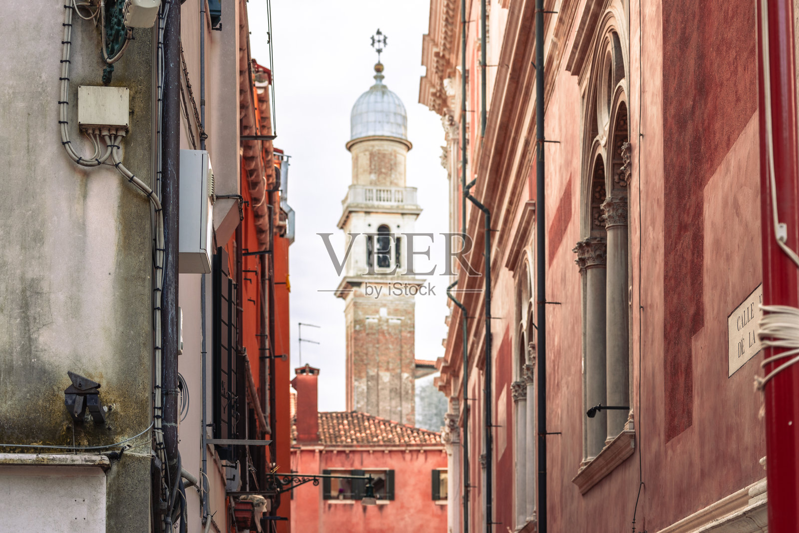 狭窄的威尼斯小巷，远处有钟楼照片摄影图片